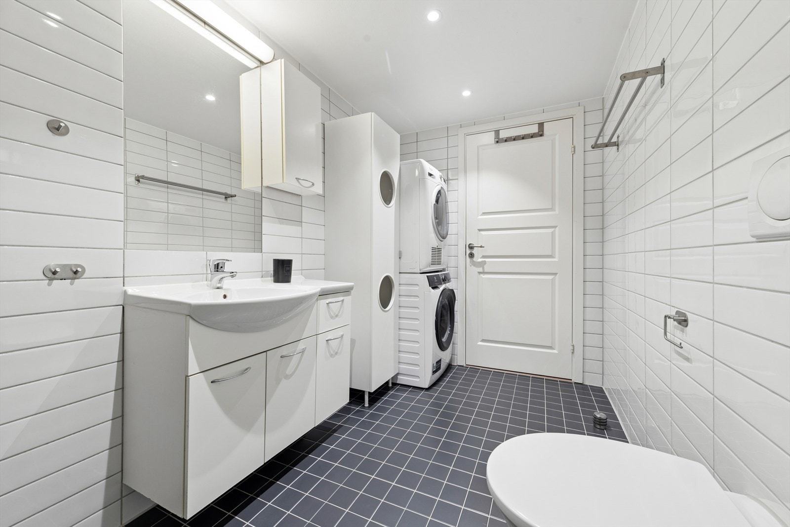 Her er det vegghengt toalett, innredning med nedfelt servant og et praktisk opplegg for vaskemaskin Galleribilde