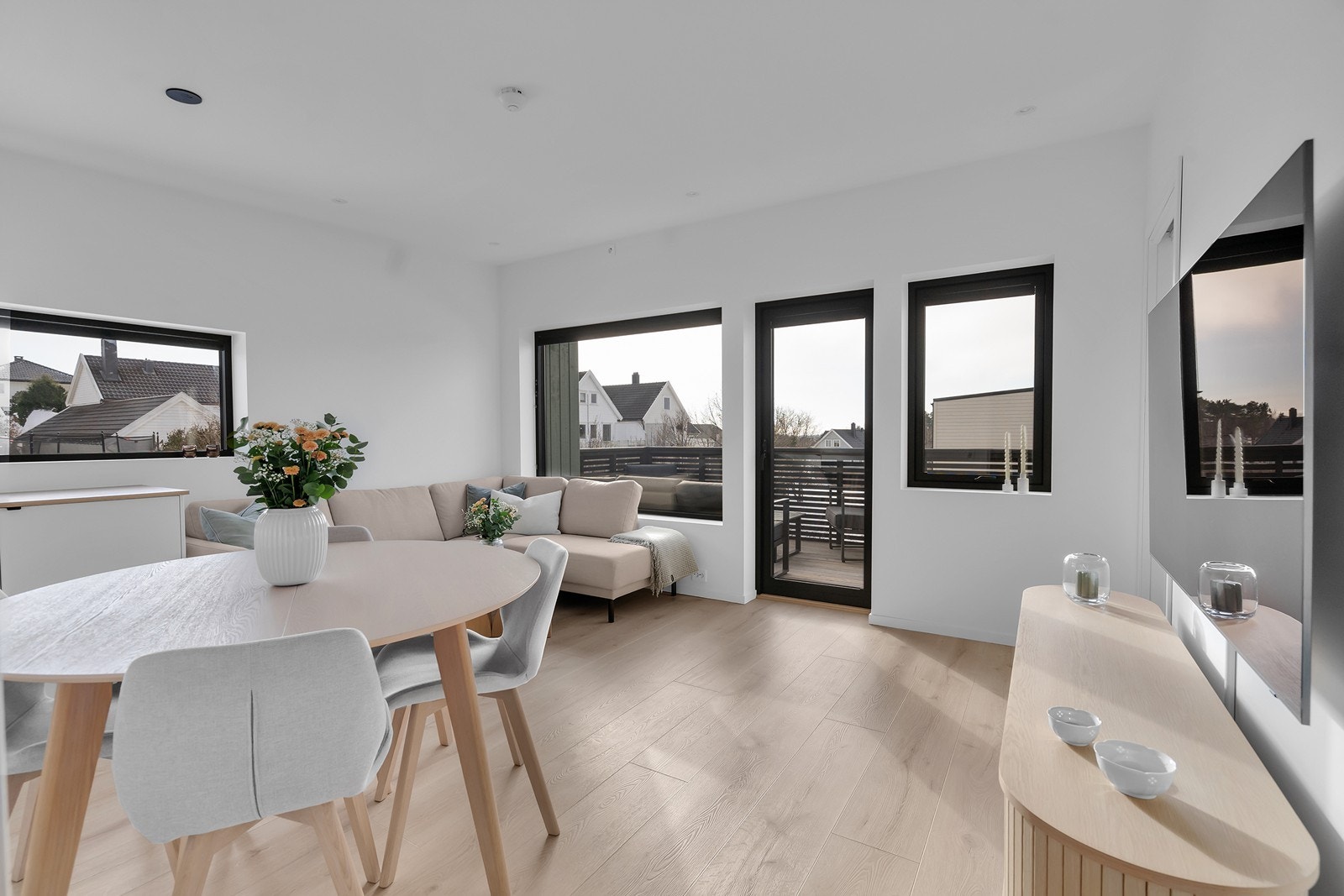 Lys og romslig stue med åpen løsning mot kjøkkenet. Store vindusflater slipper inn godt med naturlig lys og gir en luftig romfølelse. Galleribilde