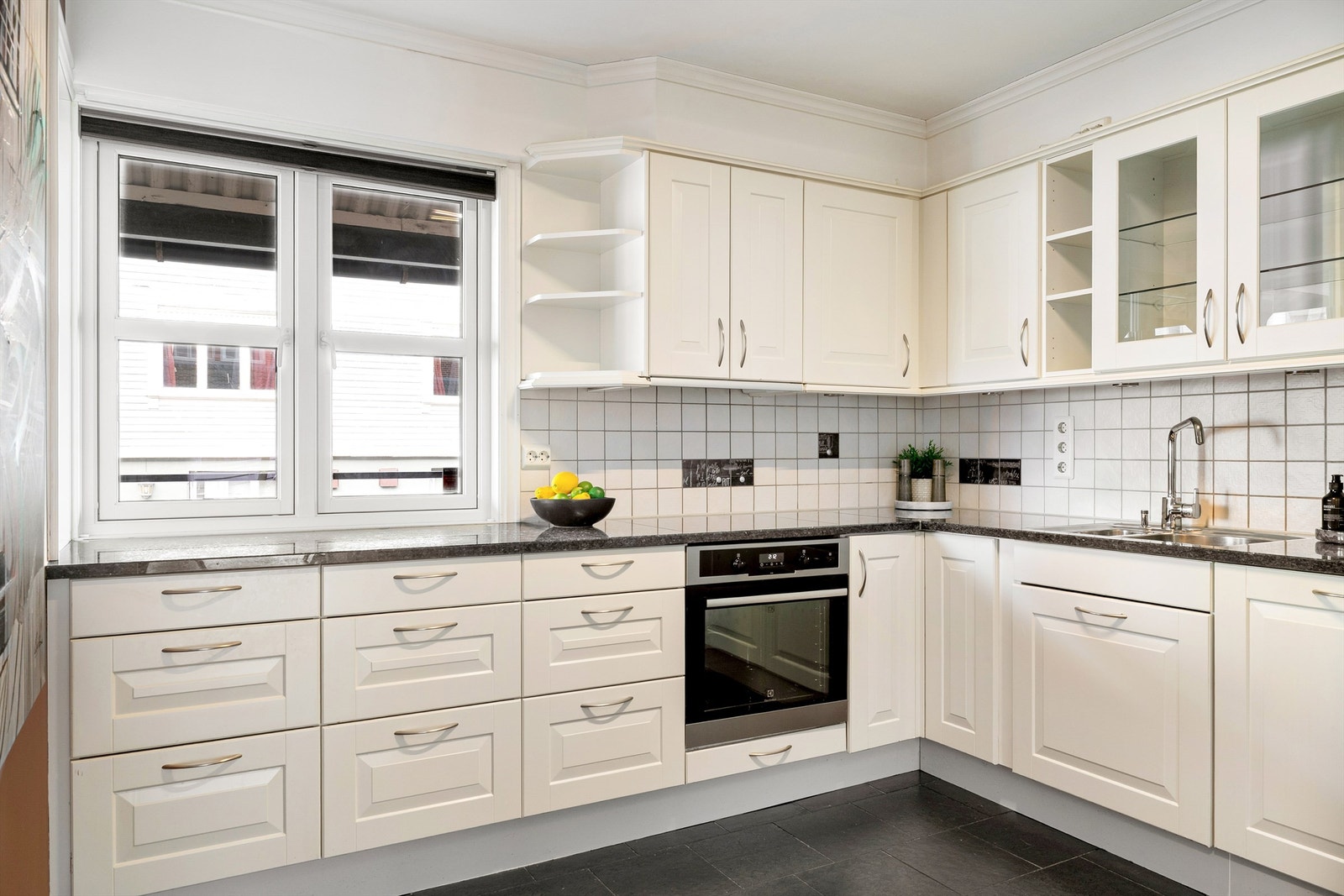 Kjøkkenet er lyst og pent med integrerte hvitevarer Galleribilde