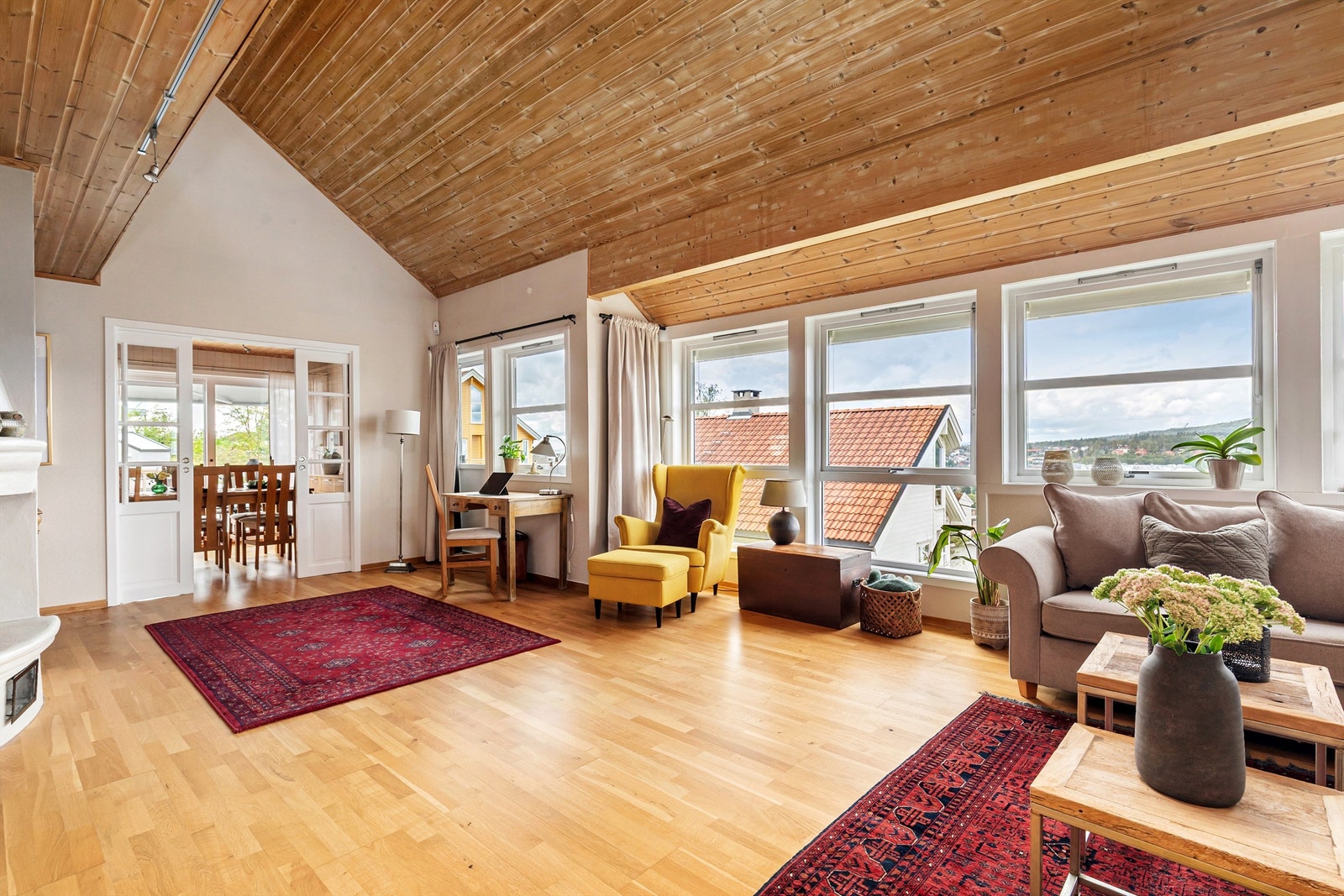 Lekre skyvedører med glassfelt skiller stuen fra spisestuen og kjøkkenet Galleribilde