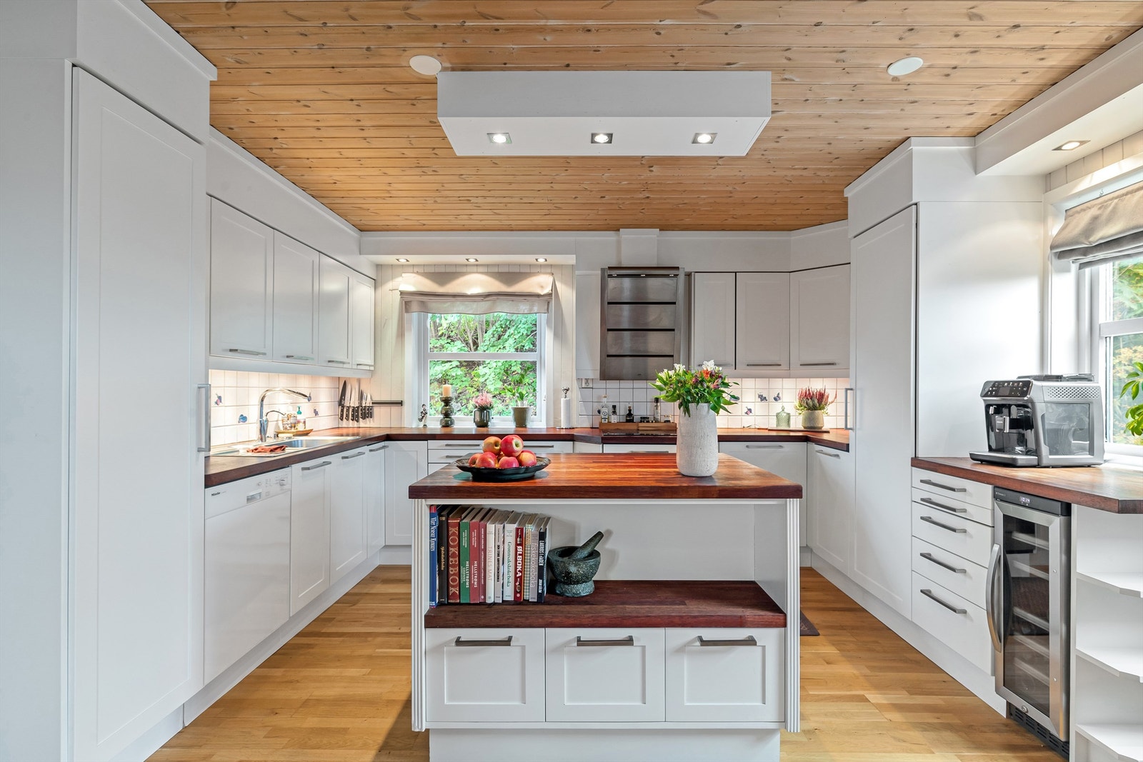 Lys kjøkkeninnredning med profilerte fronter og benkeplate av tre Galleribilde