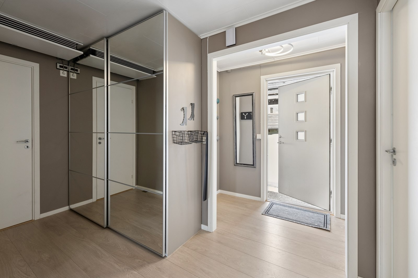 Entré og gang med god garderobeplass. Viftekonvektor tilkoblet luft-vann varmepumpe er plassert over døren til trapperom. Galleribilde