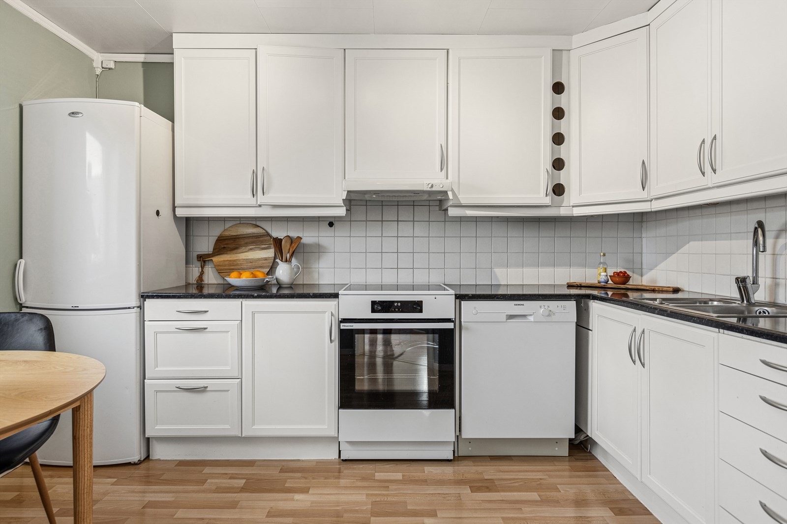 Kjøkkenet er lyst og tidløst. Innredning med hvite profilerte fronter og benkeplate av typen laminat. Galleribilde