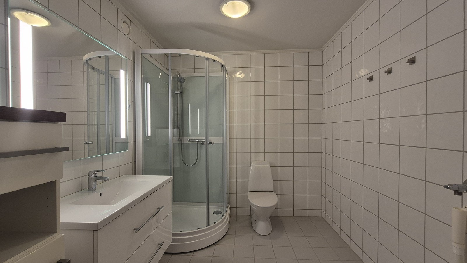 Badet er flislagt med moderne innredning og dusjkabinett, samt opplegg for vaskemaskin. Galleribilde