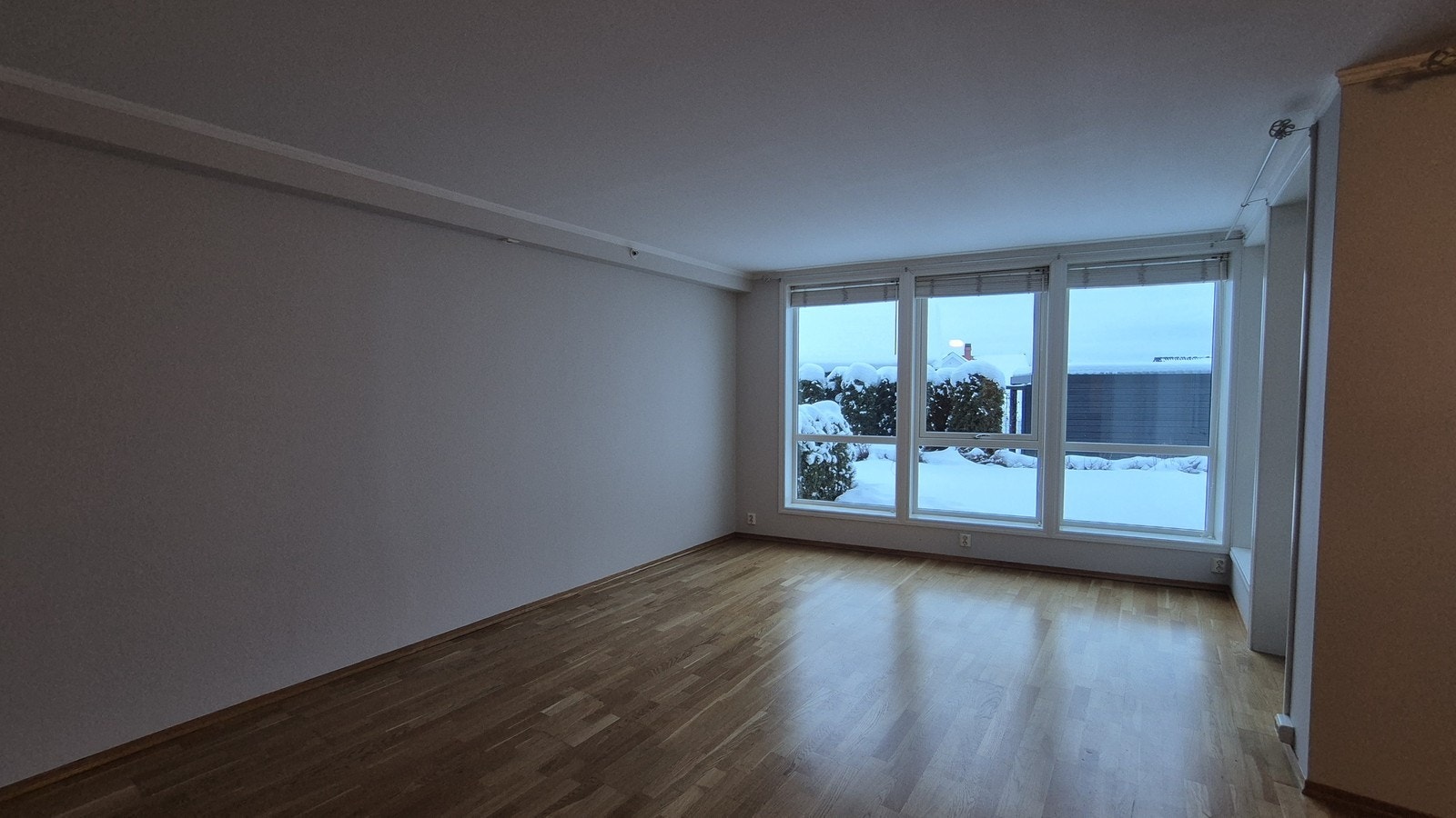 Stuen har lyse farger og store vinduer samt adkomst til terrasse og hage. Galleribilde