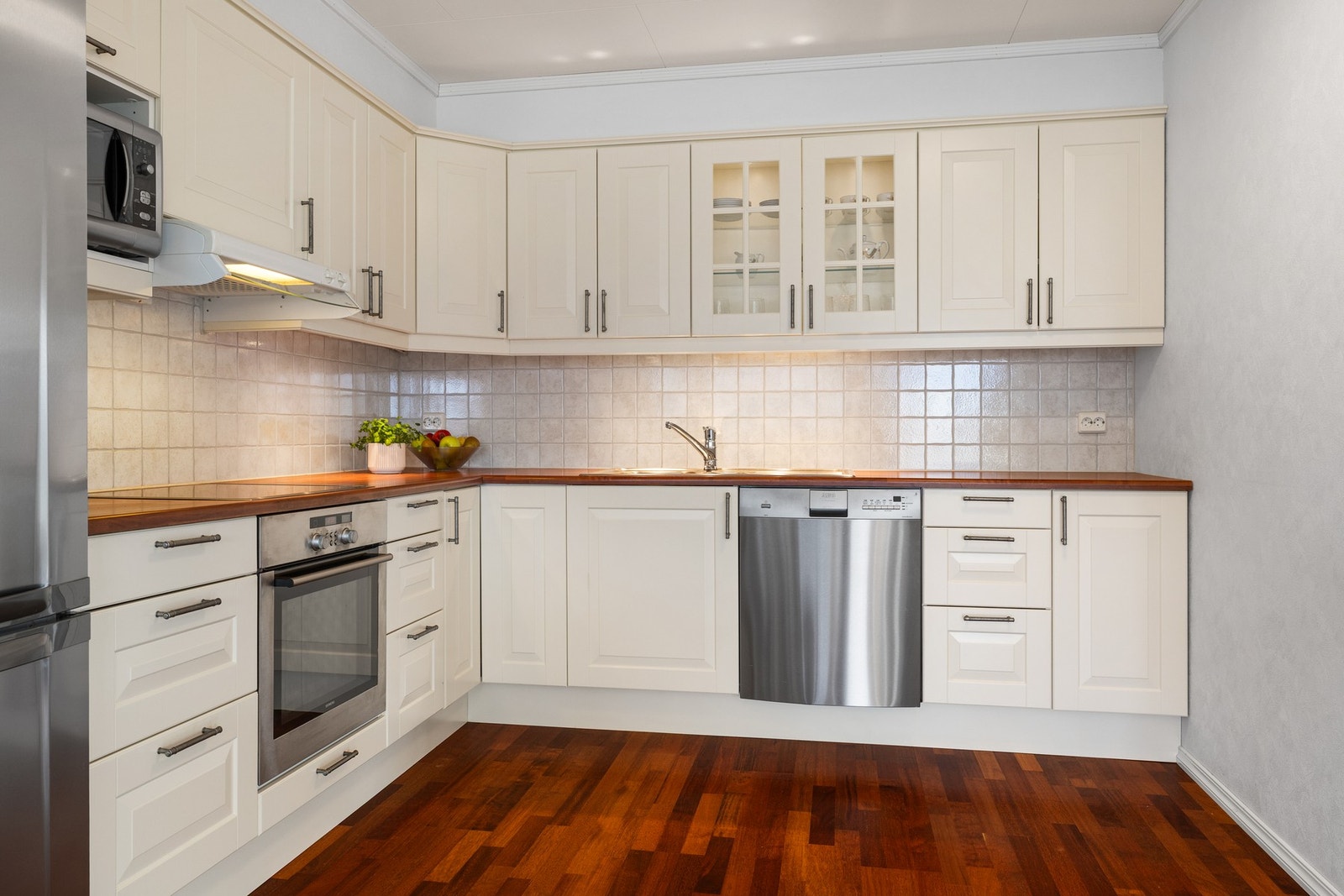 Pent og velholdt kjøkken med hvite fronter som gir en lys og luftig følelse Galleribilde