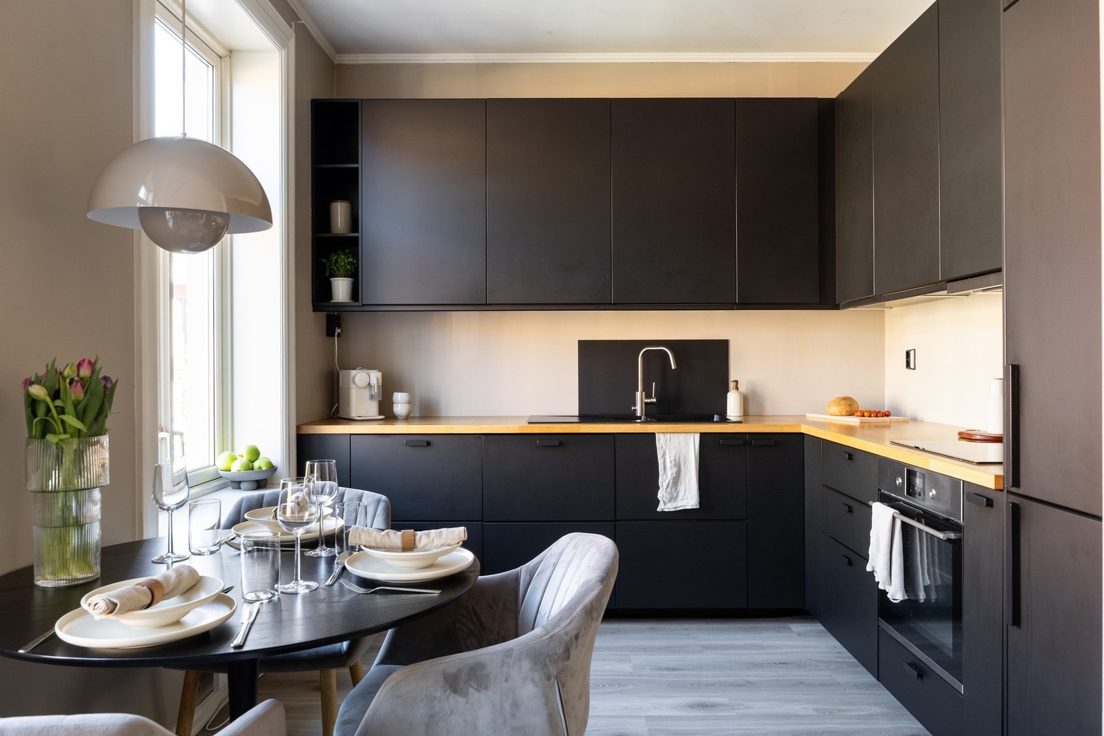 Moderne innredning fra 2018 med glatte fronter og benkeplate av tre med nedfelt kjøkkenvask. Galleribilde