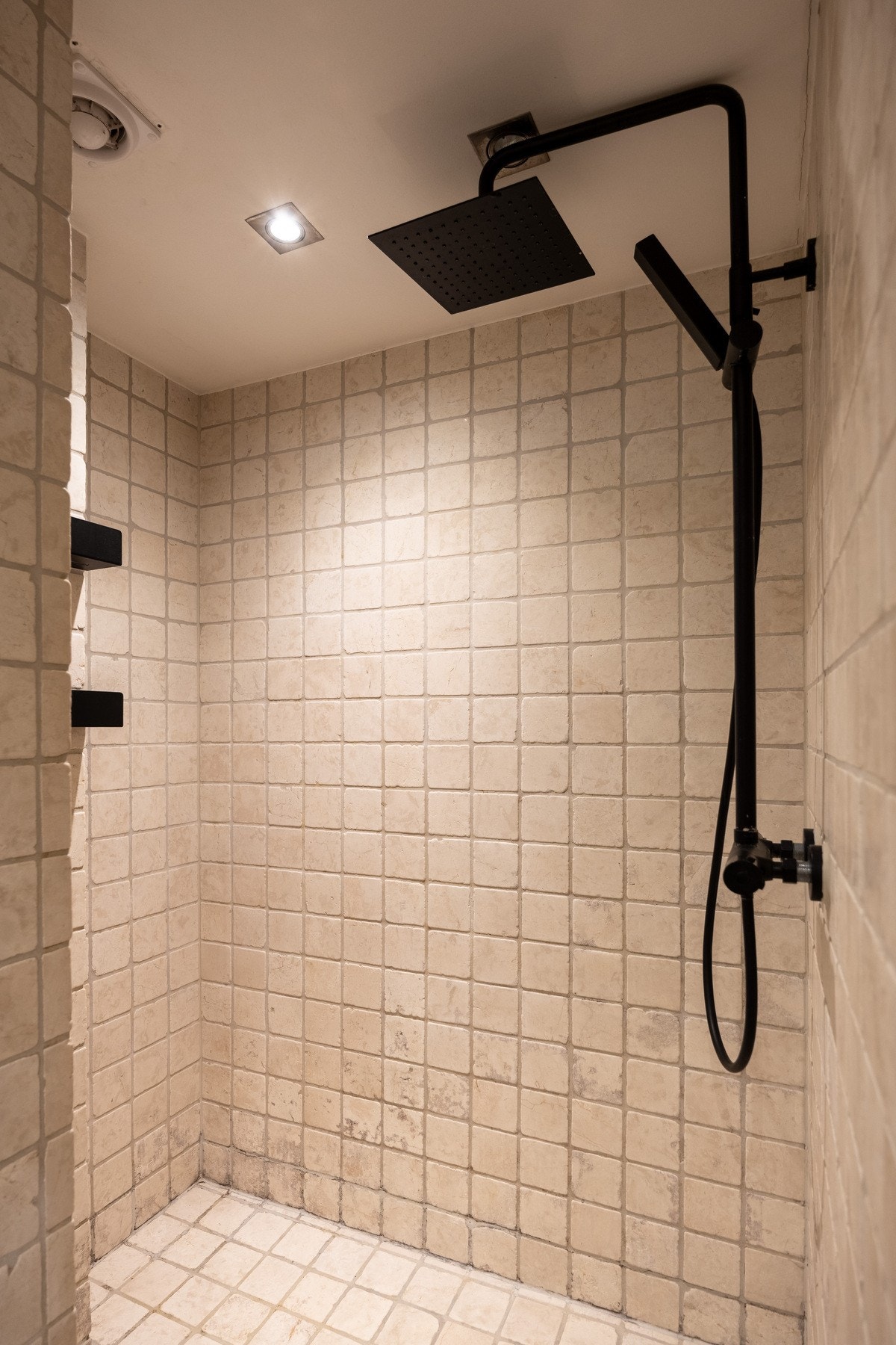 Romslig dusjhjørne med vegghengt dusjarmatur (hånddusj og regndusj). Galleribilde