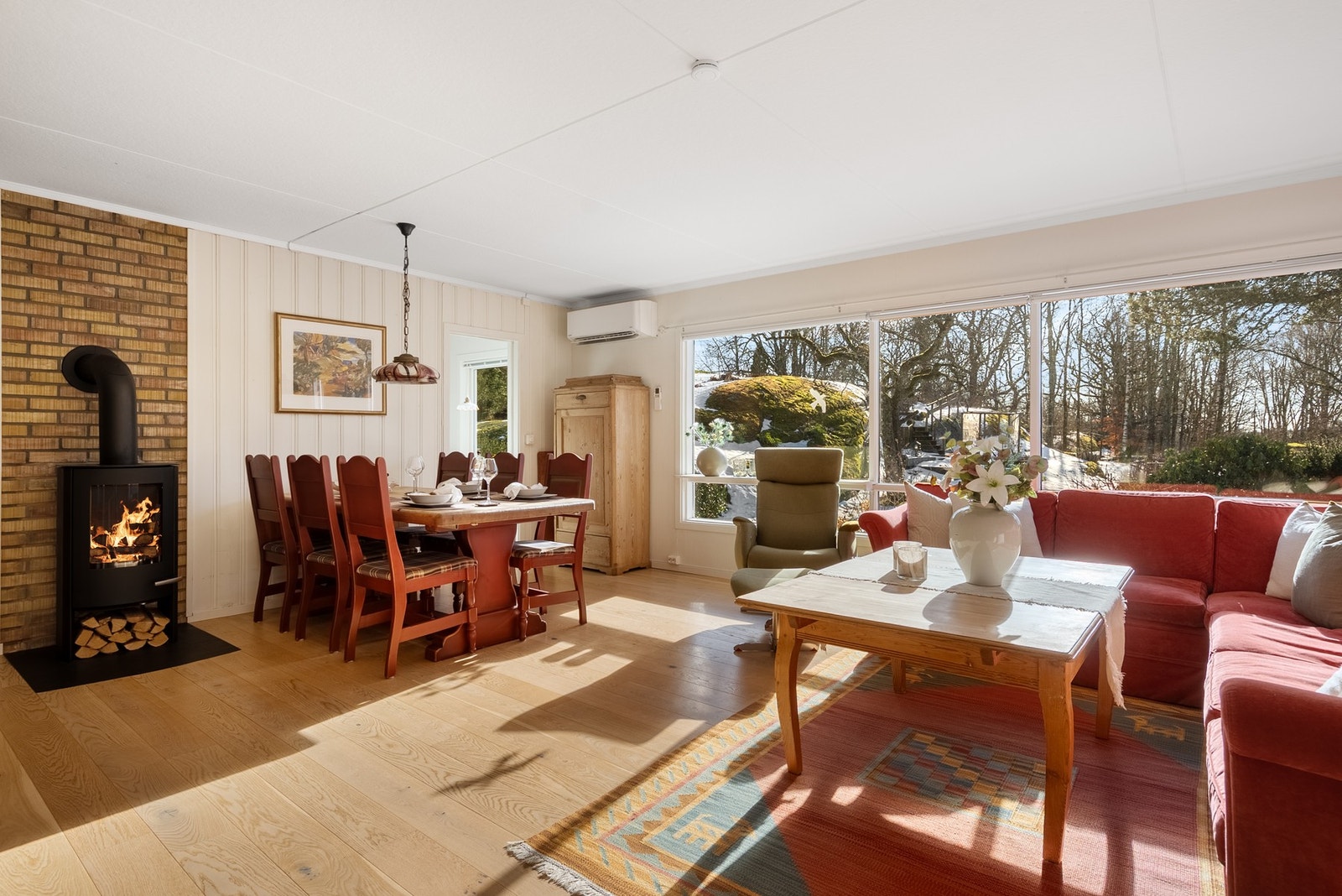Stuen står fint til terrenget utenfor og de store vinduene slipper inn både natur og naturlig lys Galleribilde