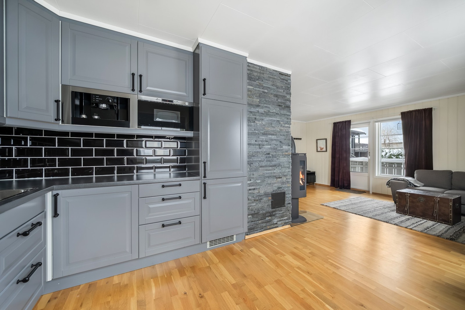 Stilfult kjøkken med glatte fronter og elegante håndtak. Galleribilde