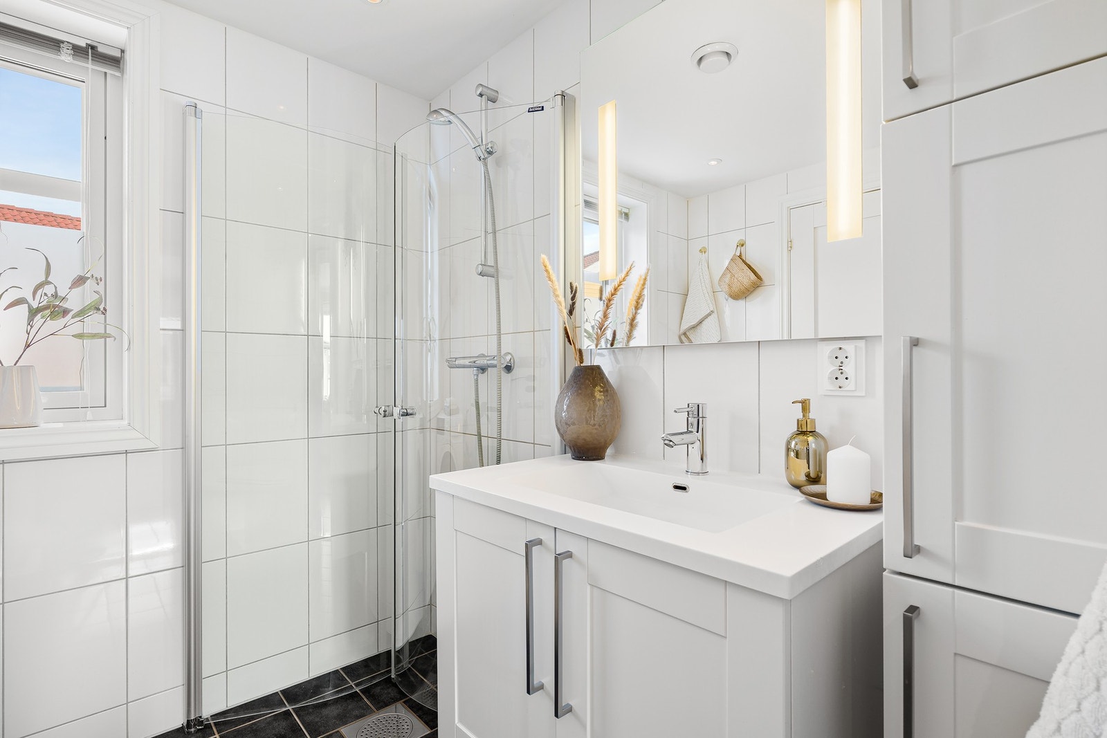 Badet er praktisk innredet med blant annet innfellbare dusjvegger og vegghengt toalett. Galleribilde