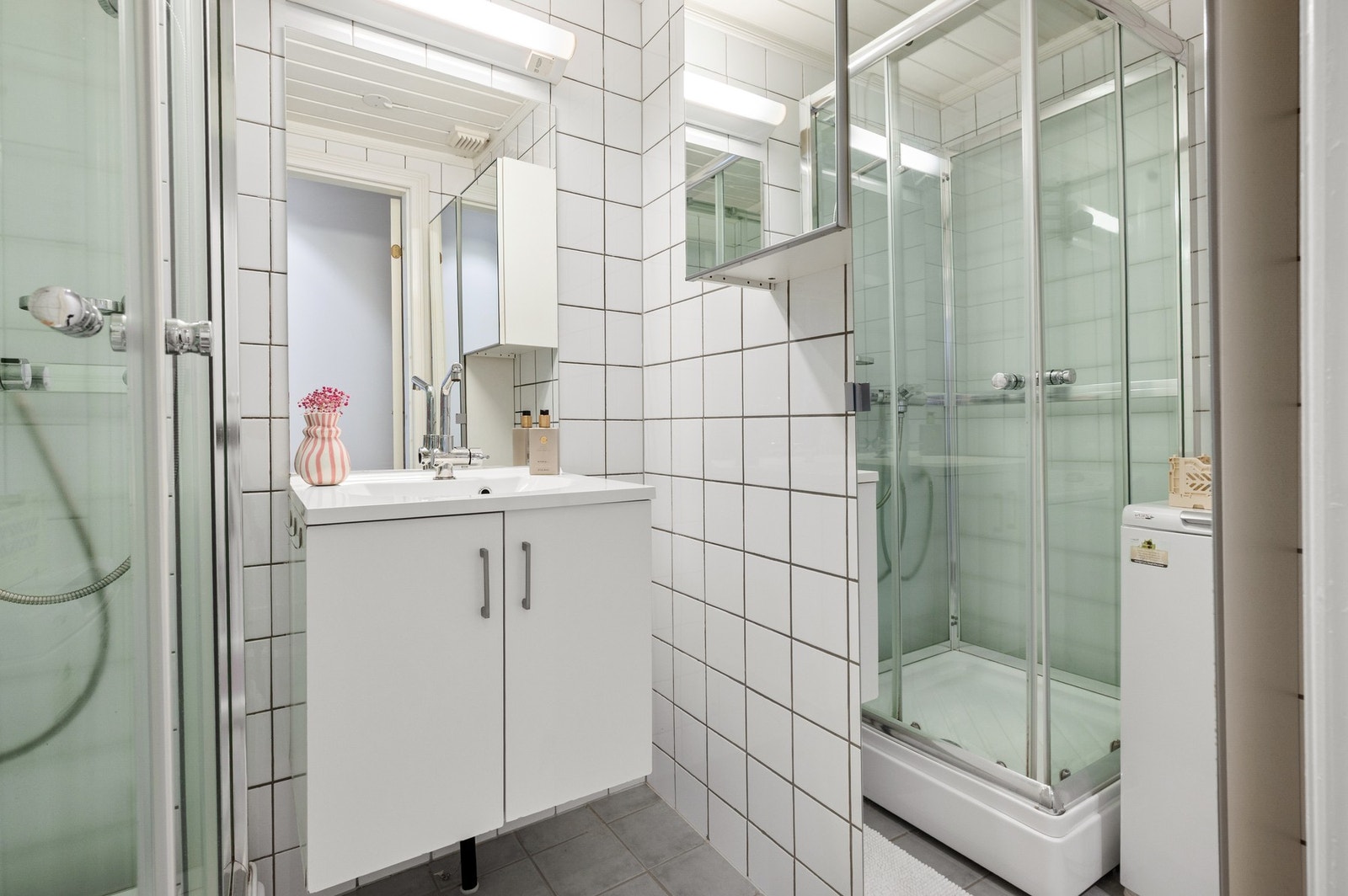 Baderommet er innredet med servant med underskap, veggskap, overskap og speil. Galleribilde