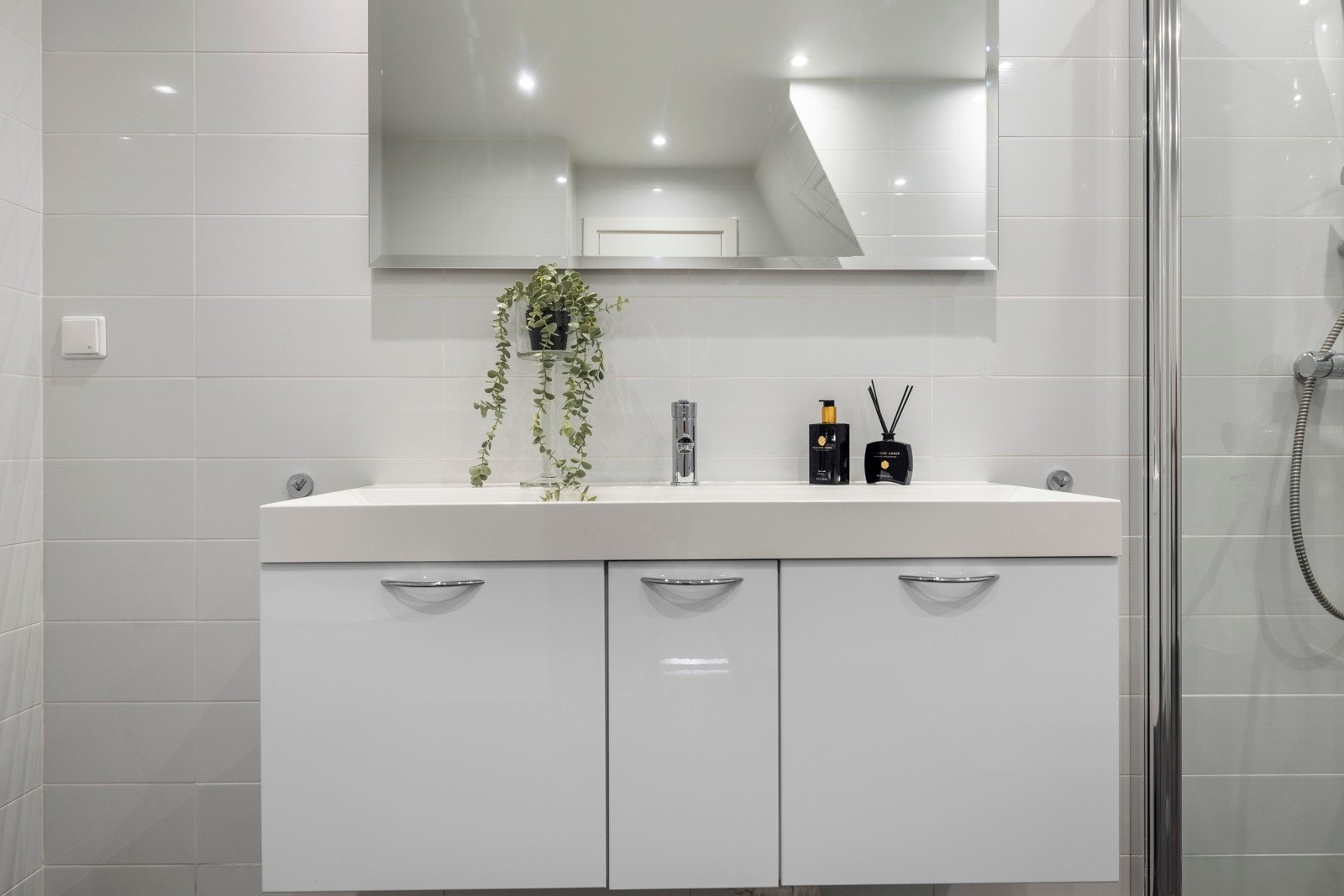 Badet har et stort speil, med vegghengt servant Galleribilde