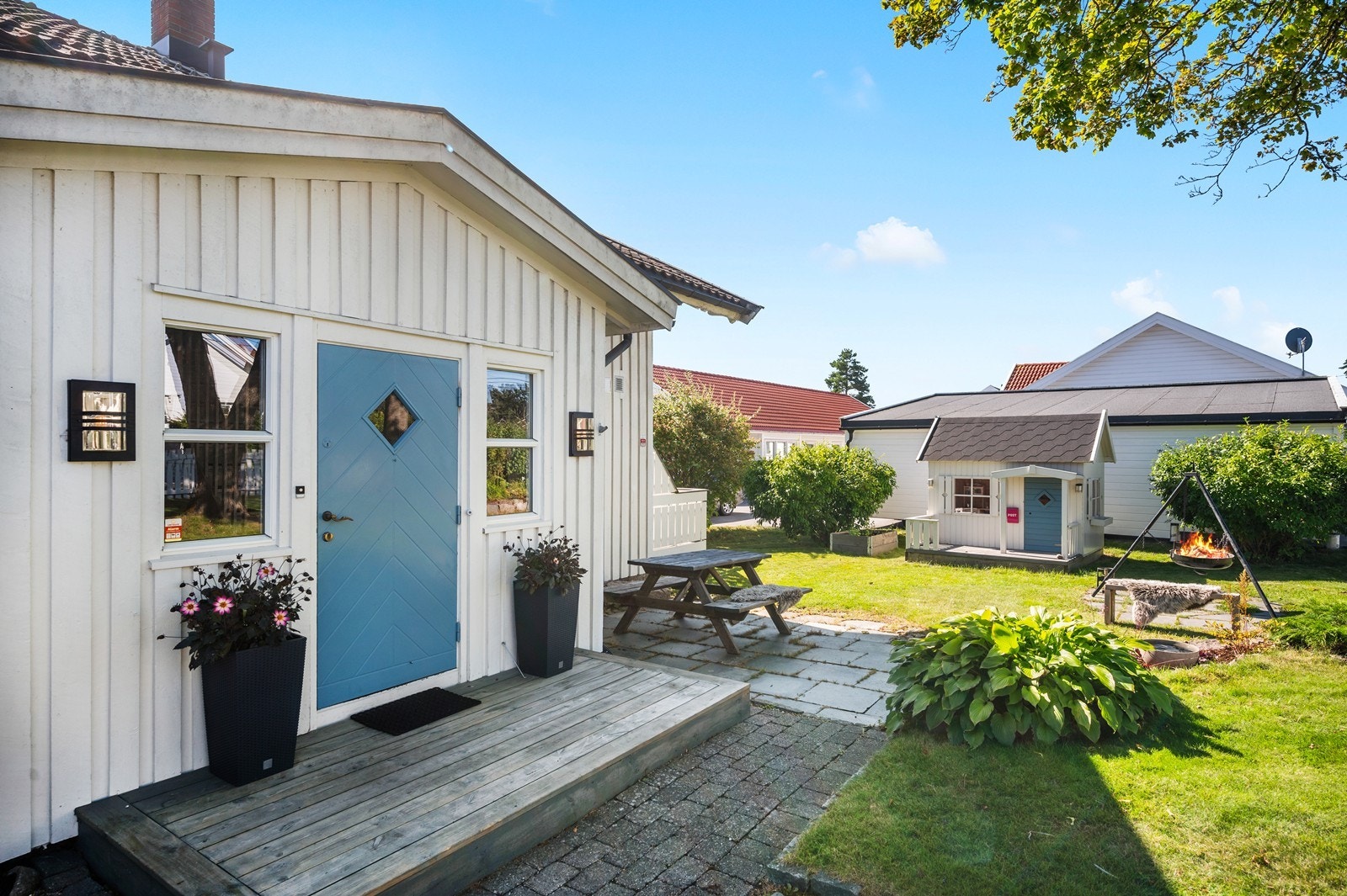 Ved inngangspartiet er det uteplasser. Det er også et lite dukkehus på tomten. Galleribilde