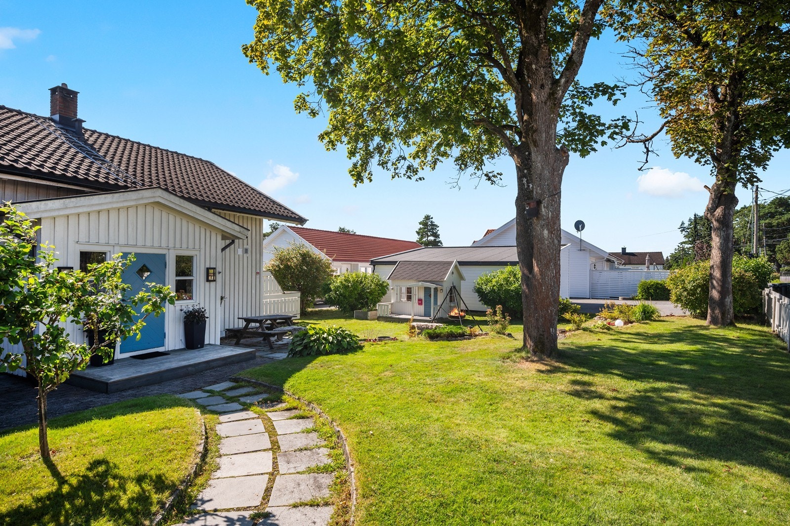 Fin gangvei med heller og kantstein fra parkering/garasje. Galleribilde