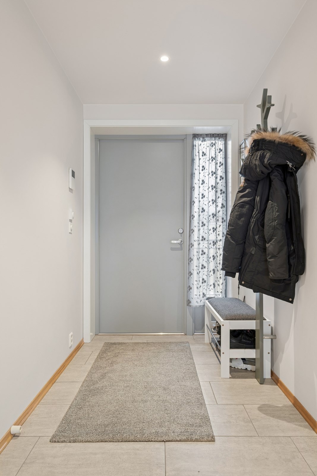 Velkommen inn i en romslig og innbydende entré med flislagt gulv og god plass til yttertøy og sko. Inngangspartiet er lyst og praktiske og gir et godt førsteinntrykk og setter tonen for resten av leiligheten Galleribilde