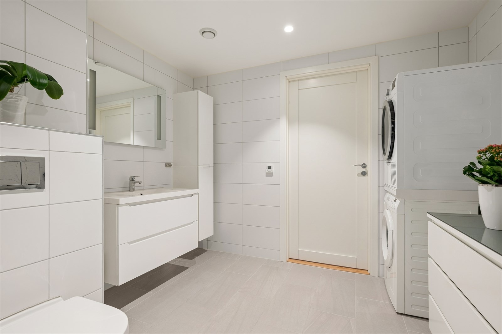 Lys og moderne baderomsinnredning med mye oppbevaringsplass. Opplegg for vaskemaskin/tørketrommel. Galleribilde