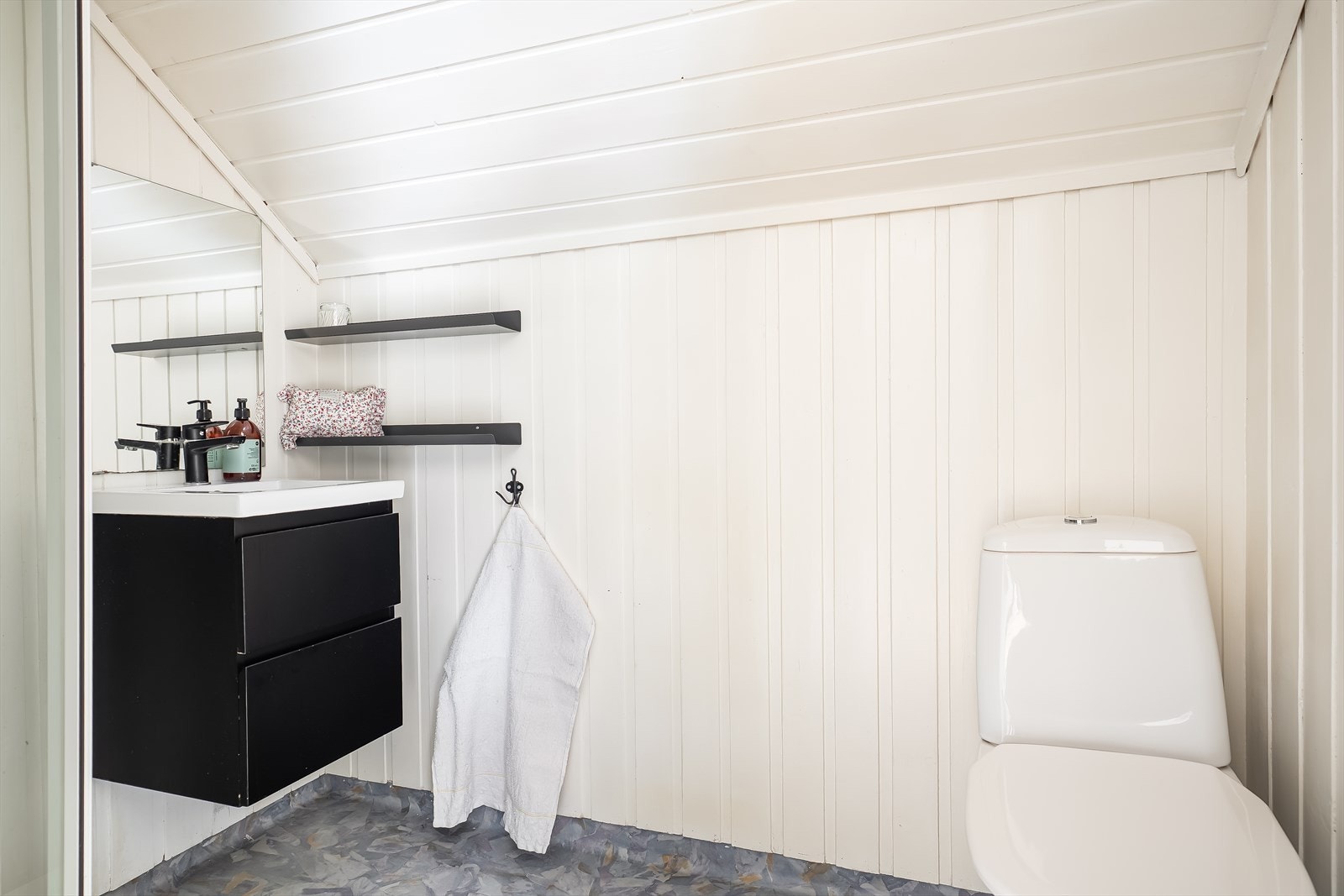 Badet er utstyrt med vegghengt servantinnredning, speil, toalett og dusjkabinett. Galleribilde