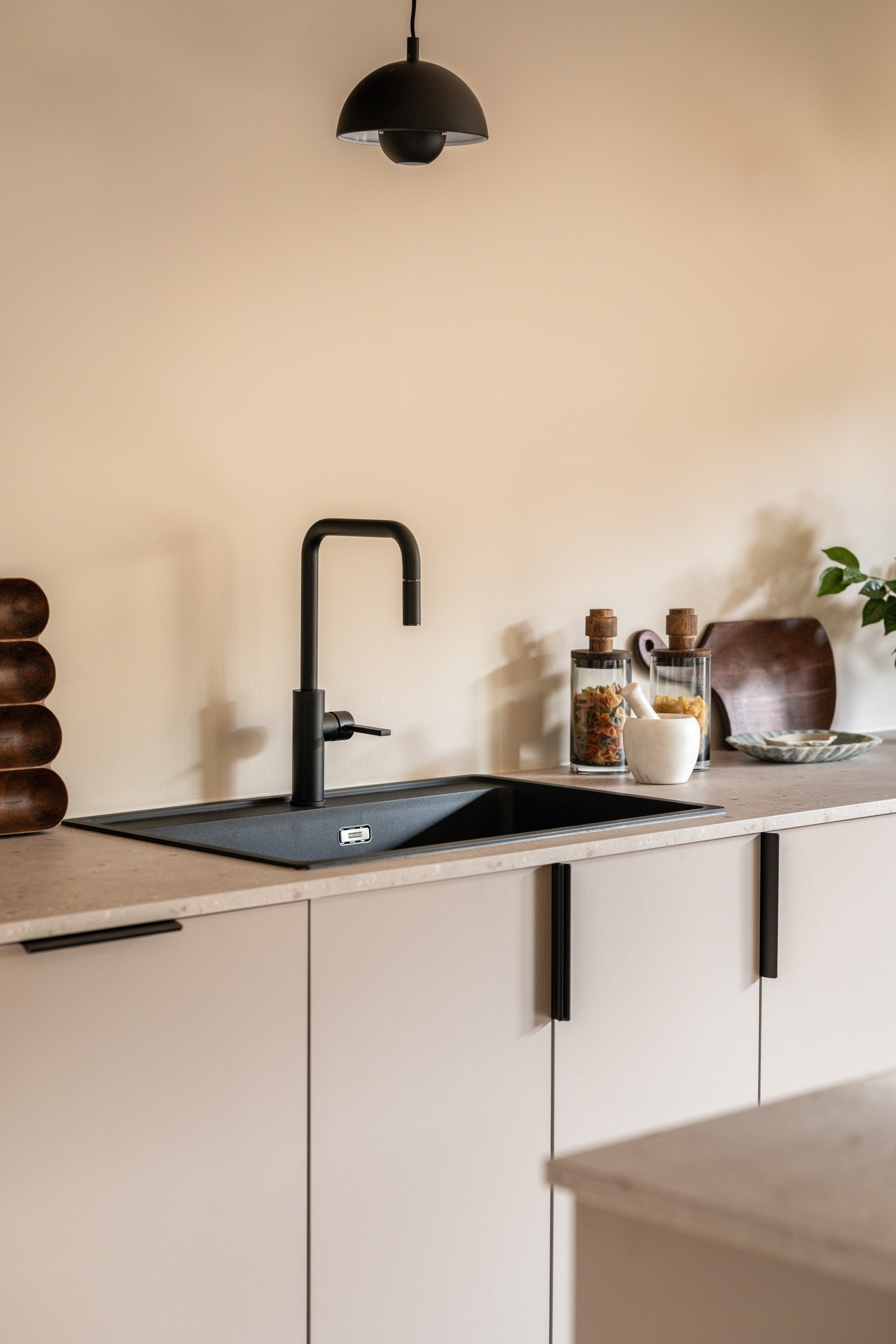 Nedfelt sort oppvaskkum med stilrent sort armatur med uttrekkbar tut. Galleribilde