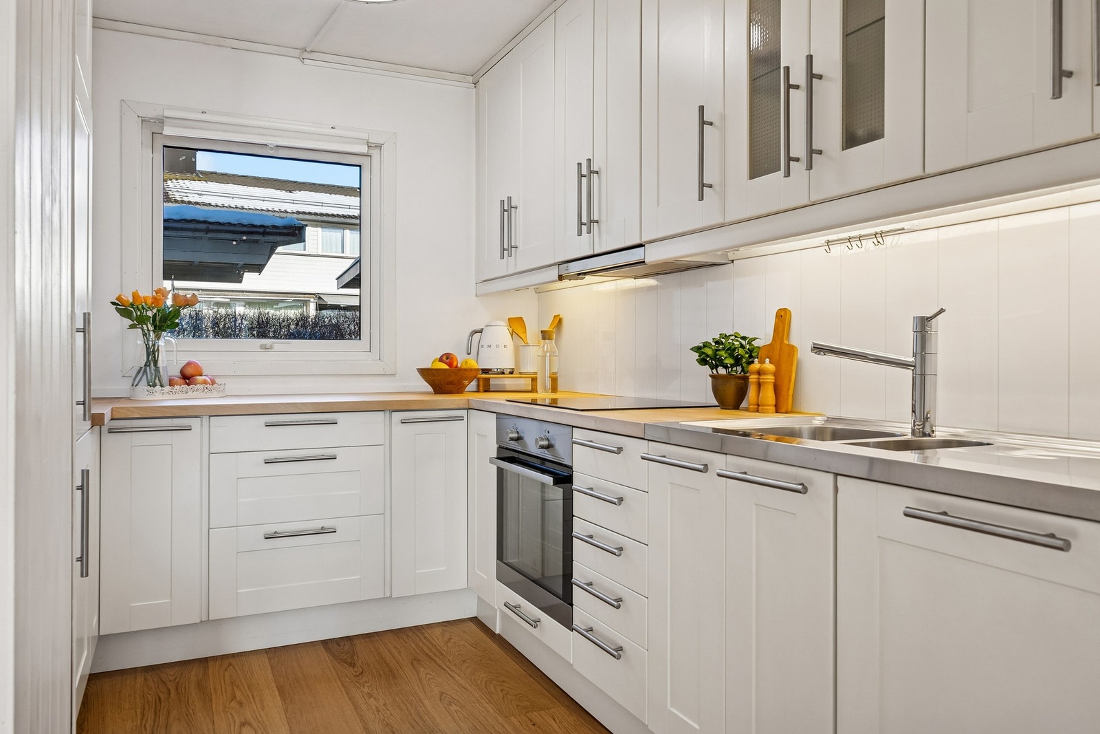 Stilrent kjøkken med en praktisk og funksjonell utforming som gir rikelig med både skapplass og benkeplass. Galleribilde