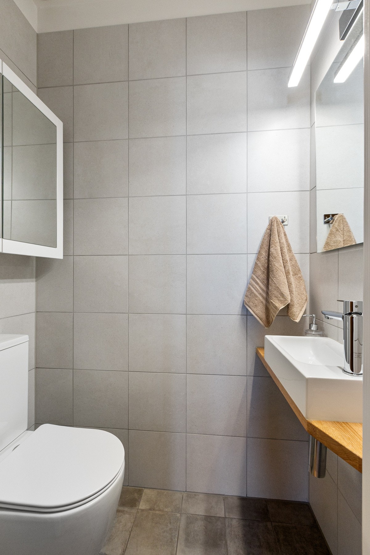 Flislagt WC-rom med servant, speil, speilskap og WC Galleribilde