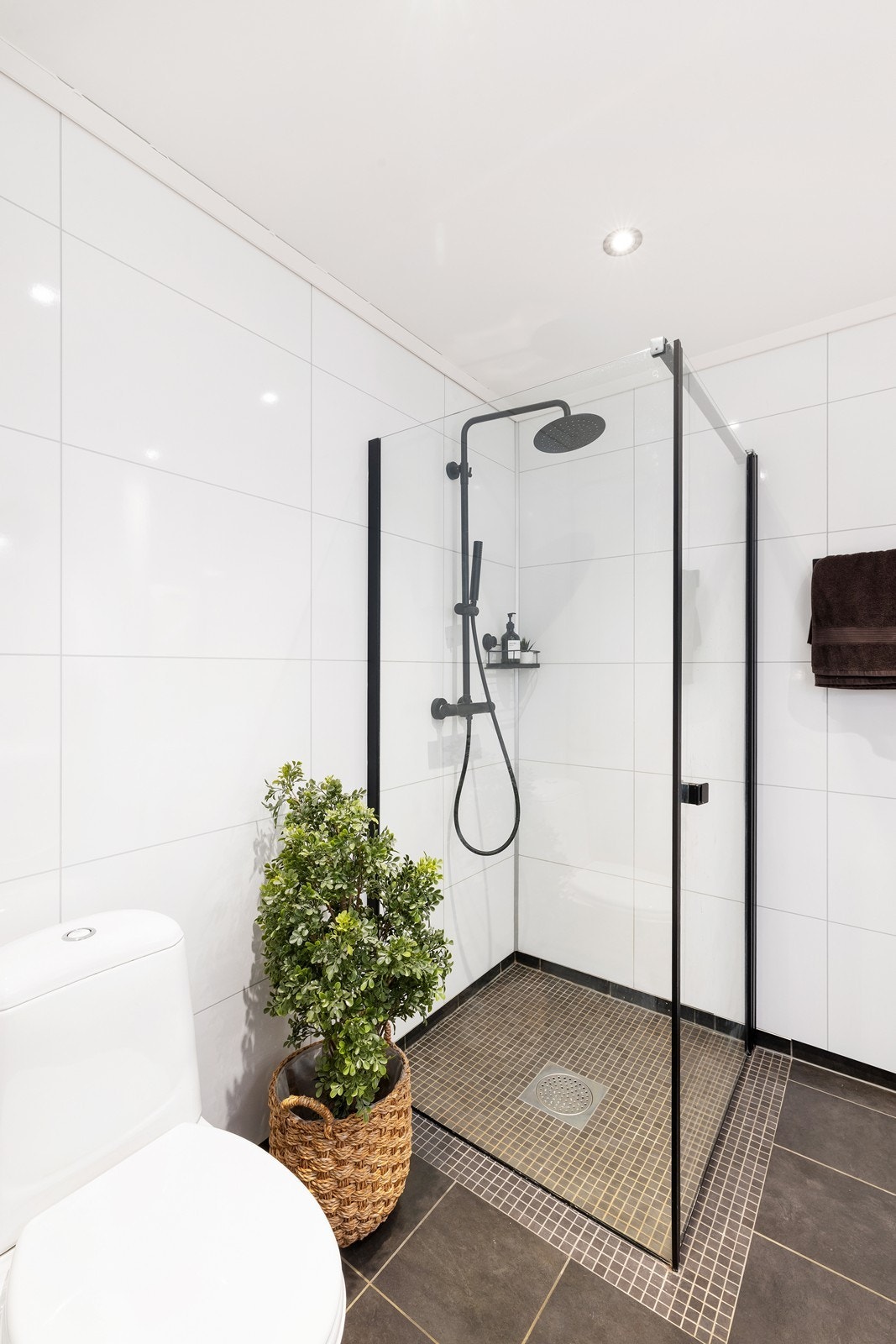 Pent og moderne med dusjhjørne i glass og svart dusjgarnityr. Galleribilde