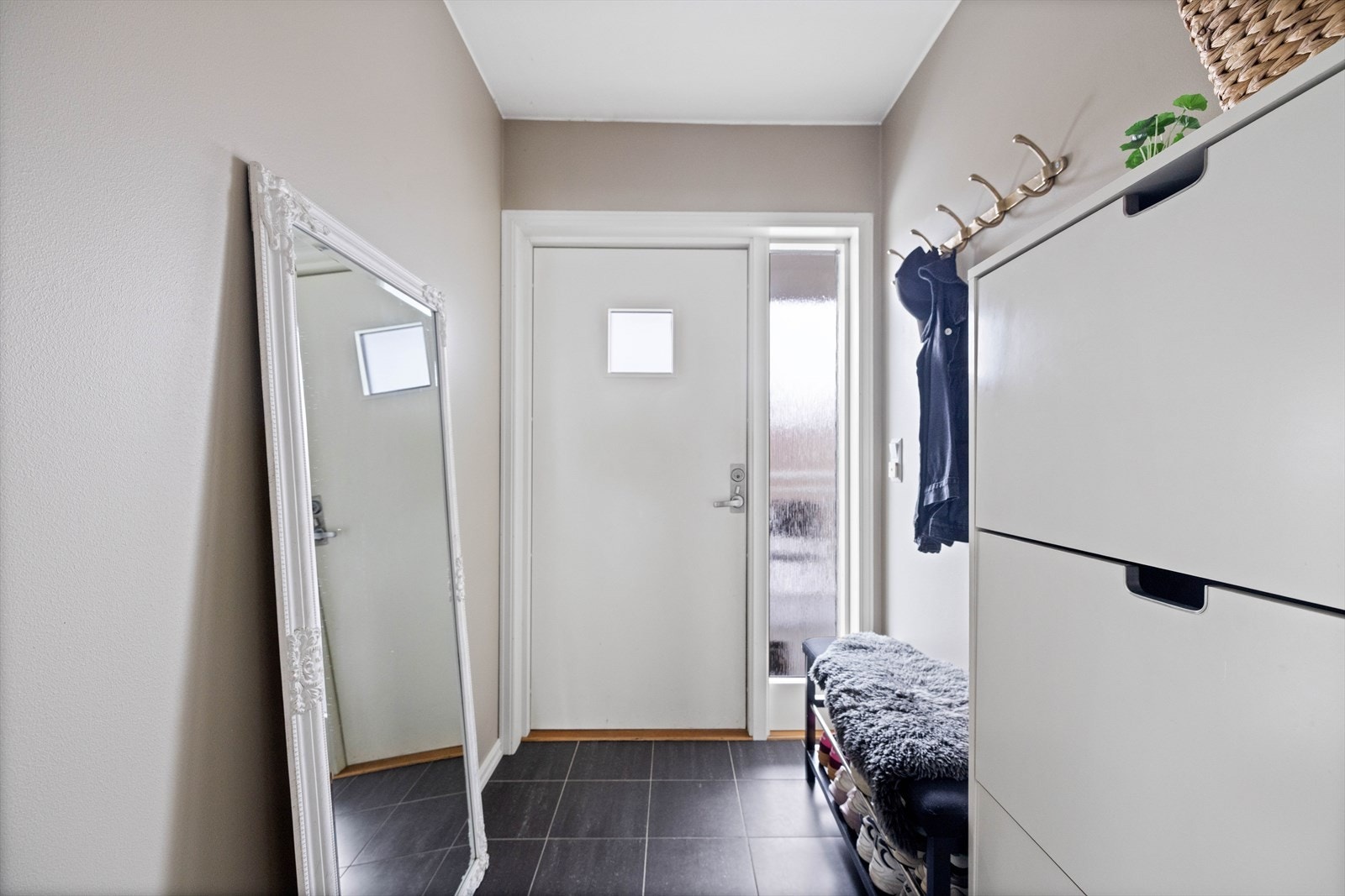 Entréen er delvis flislagt med gulvvarme og har plass til oppbevaring av yttertøyet. Galleribilde