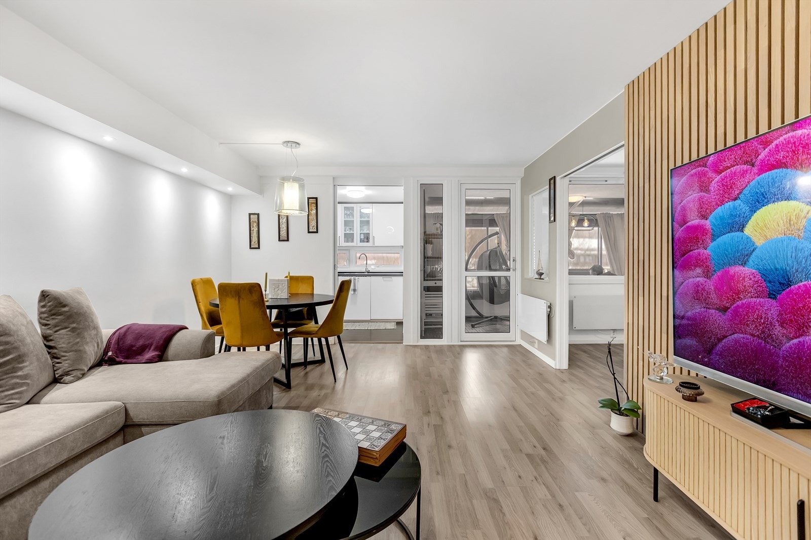 Stue med fin siktlinje mot spiseplass og inngangsparti, som gjør rommet sosialt og åpent. Galleribilde