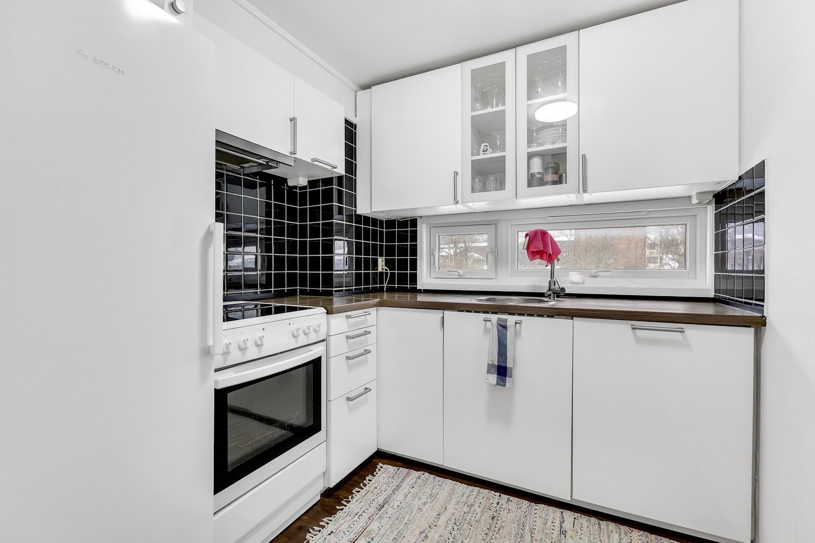 Kjøkken med kontrastfull flis og fine arbeidsflater - ryddig og tidløst uttrykk. Galleribilde