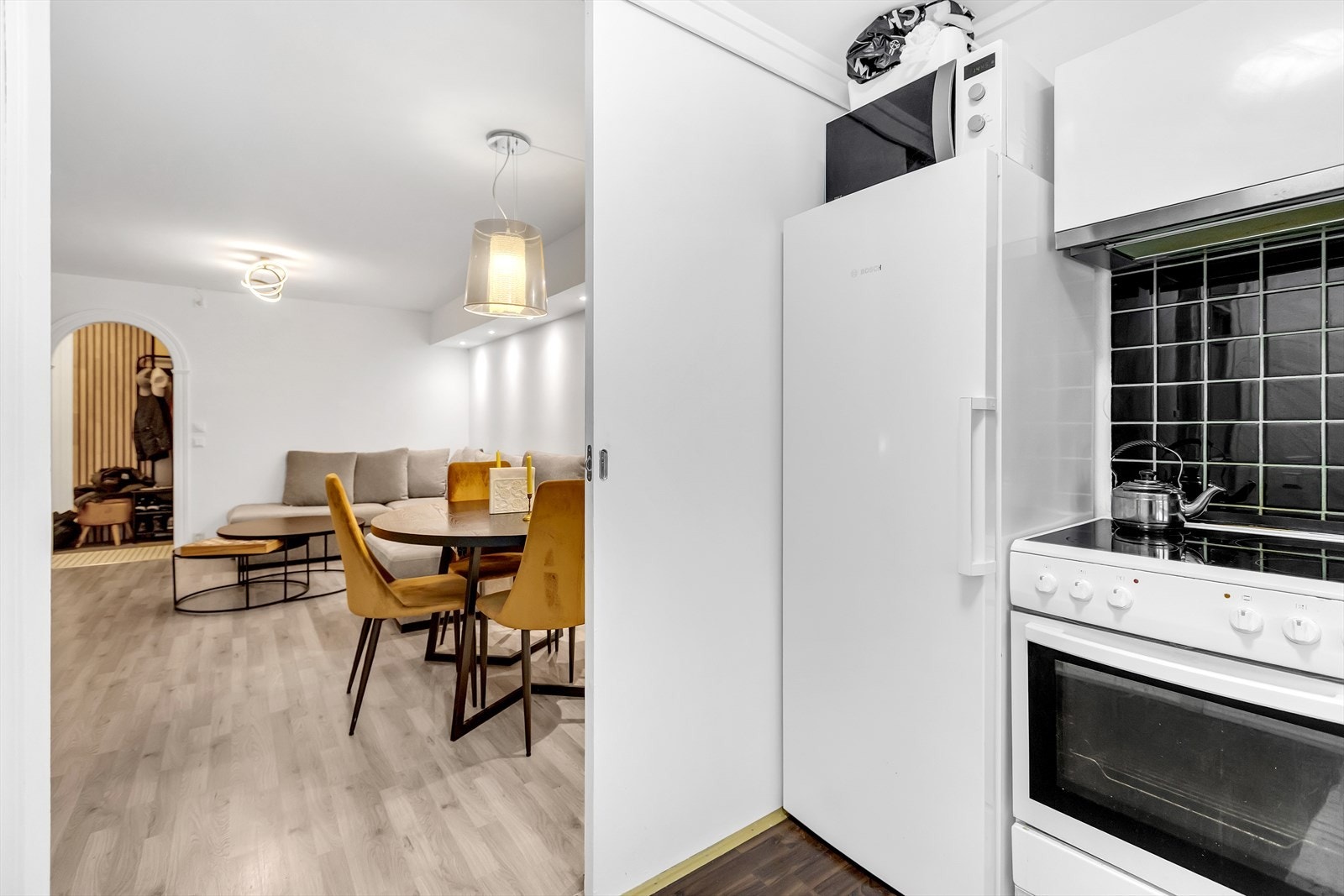 Kjøkken mot stue/spiseplass - praktisk løsning som gjør det enkelt å lage mat mens man har gjester. Galleribilde