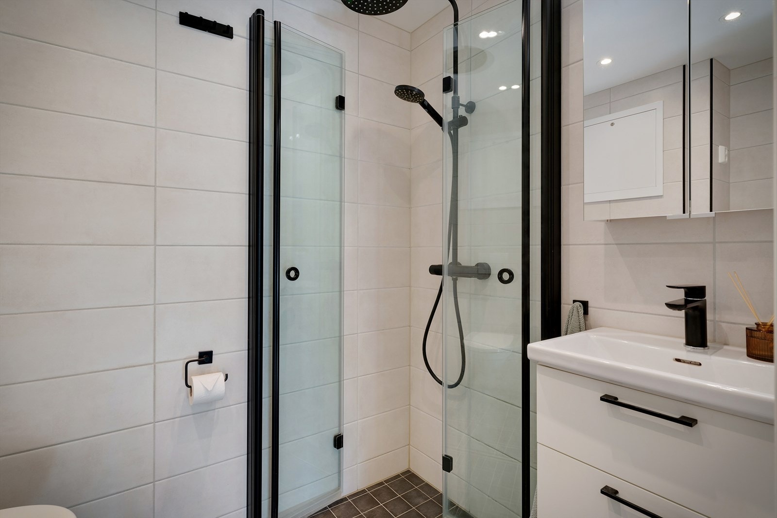 - Lyst bad med hvit servantinnredning, speil og praktisk oppbevaring - Galleribilde