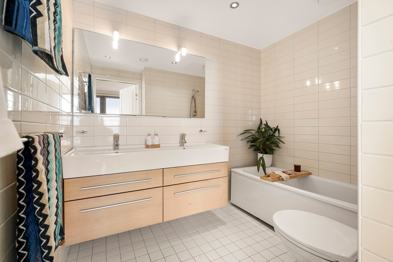 Badet har dobbel servantinnredning med skuffer og ovenpåliggende servant, samt speil på vegg over servant. Galleribilde