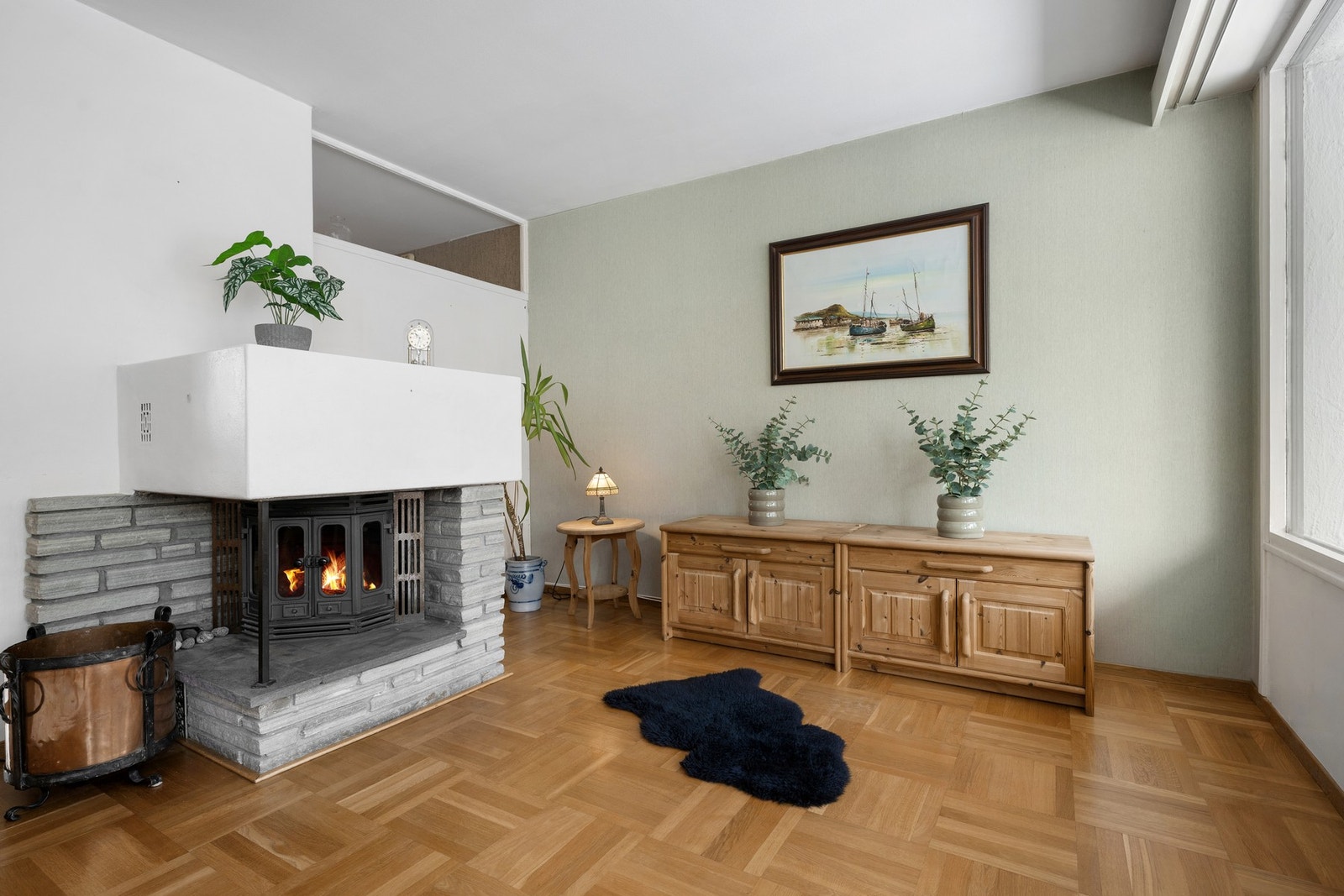 Murt peis med innsats gir stuen et lunt og klassisk preg, og fungerer som et naturlig samlingspunkt i rommet. Galleribilde
