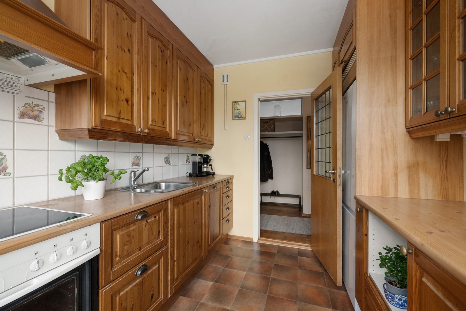 Praktisk kjøkkenløsning med heltre fronter, god oppbevaringsplass og flislagt vegg over benkeplate. Galleribilde