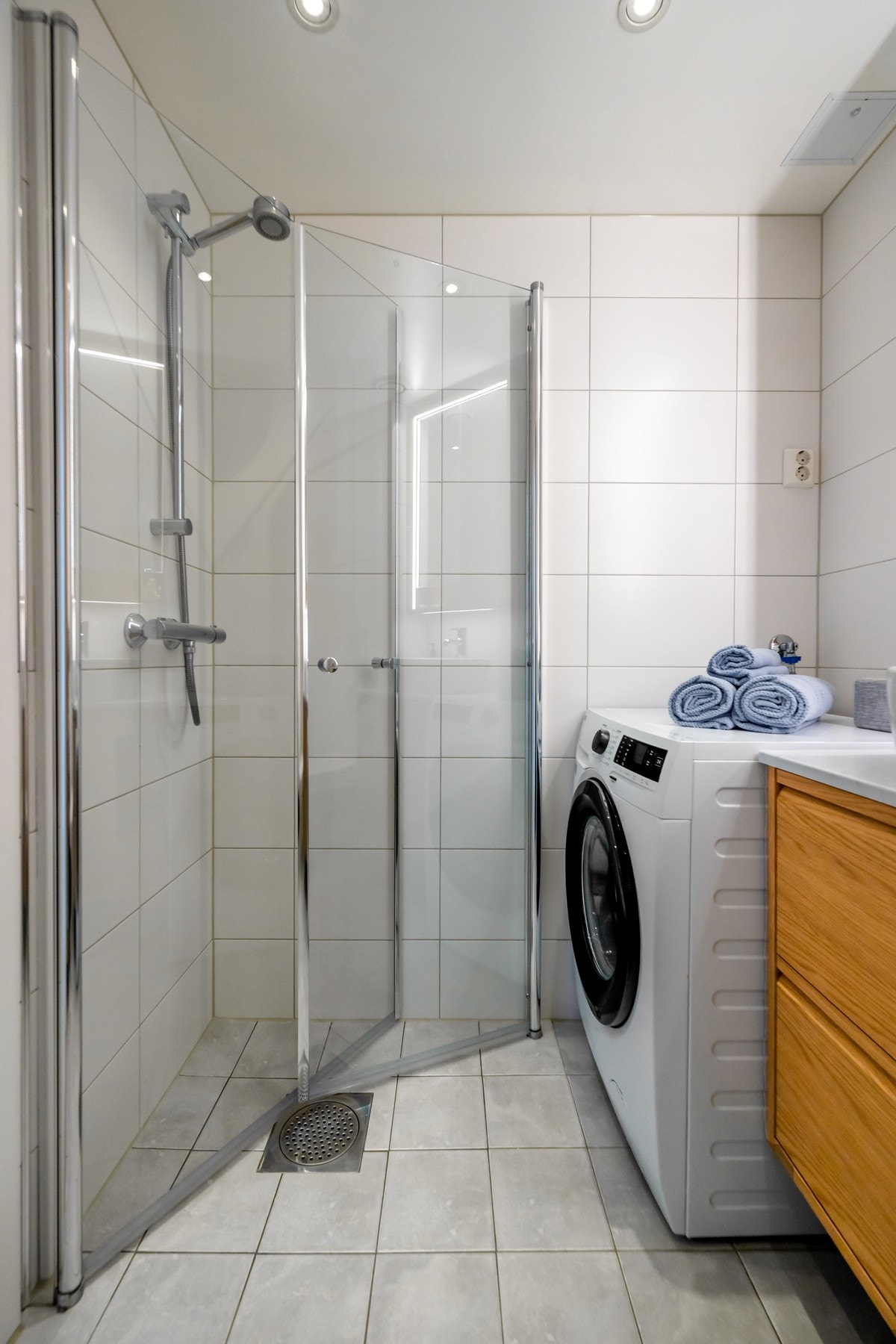 Rommet er utstyrt med varmekabler i gulv, vegghengt toalett, servant med underskap, speil med belysning samt dusjhjørne med glassvegger. Galleribilde