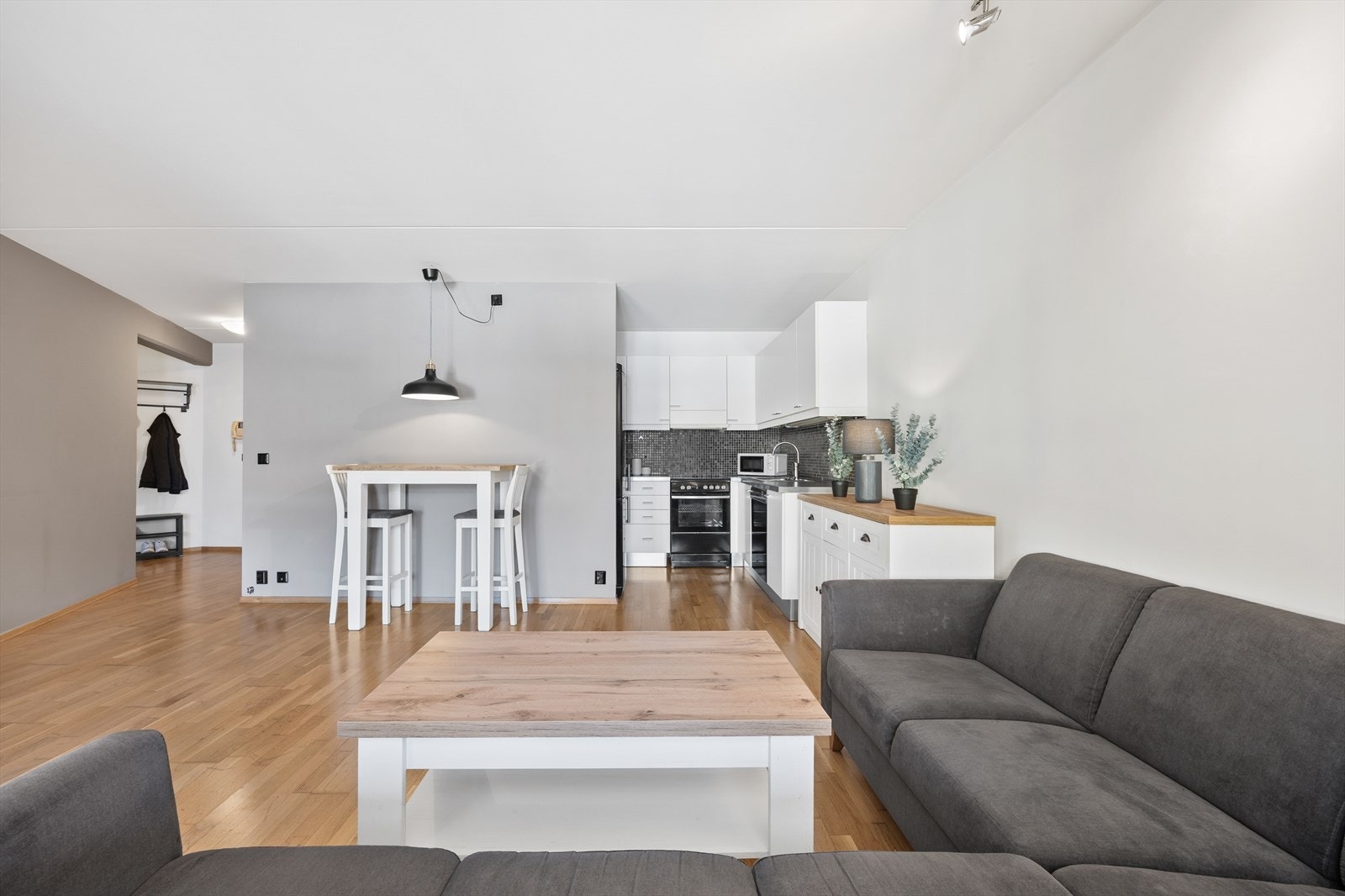 Lys stue i delvis åpen planløsning med kjøkkenet. Galleribilde