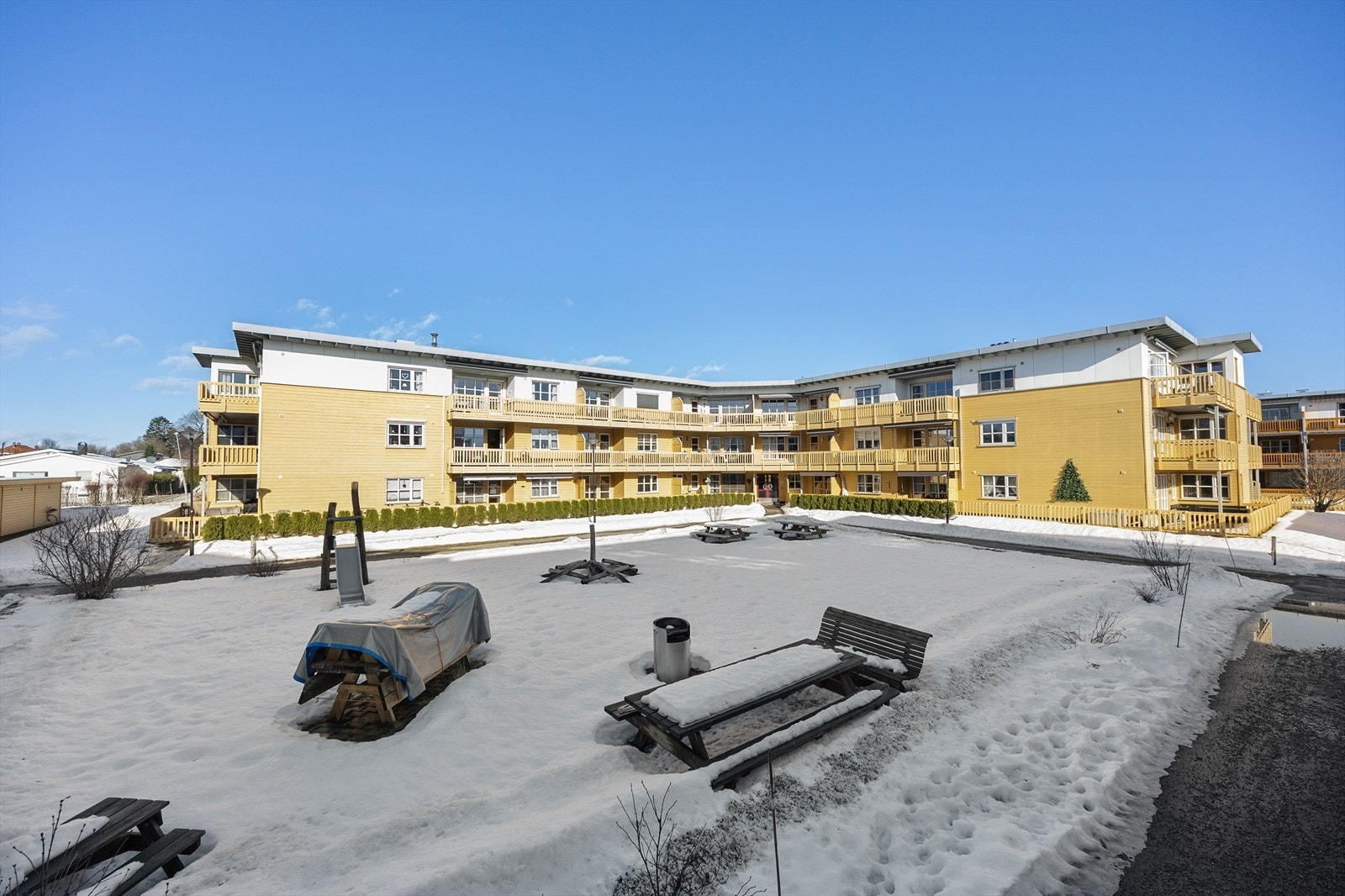 Fint fellesområde som er opparbeidet med plen, lekeplass og sittegrupper. Galleribilde