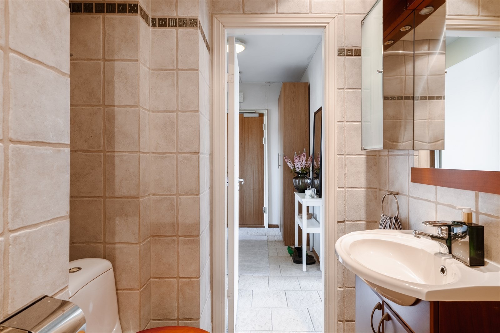 Badet er innredet med servant i skapseksjon og overskap for oppbevaring. Videre er det gulvmontert toalett og dusjhjørne. Galleribilde