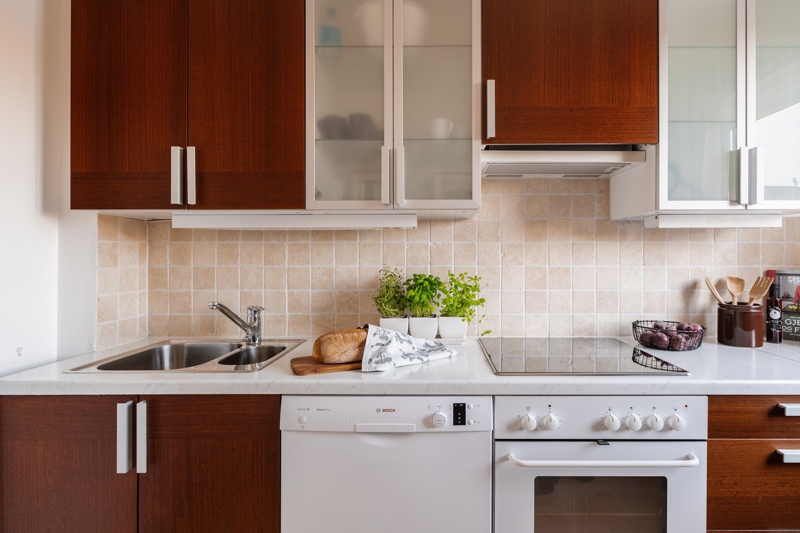 Mørk kjøkkeninnredning med glatte flater, laminert benkeplate og nedfelt oppvaskkum. Galleribilde