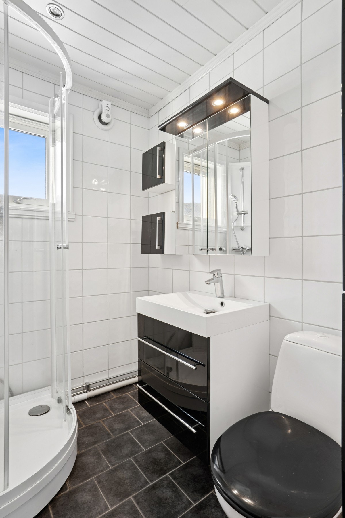 Rommet er utstyrt med dusjkabinett, servantinnredning, speilskap og mekanisk avtrekk. Galleribilde