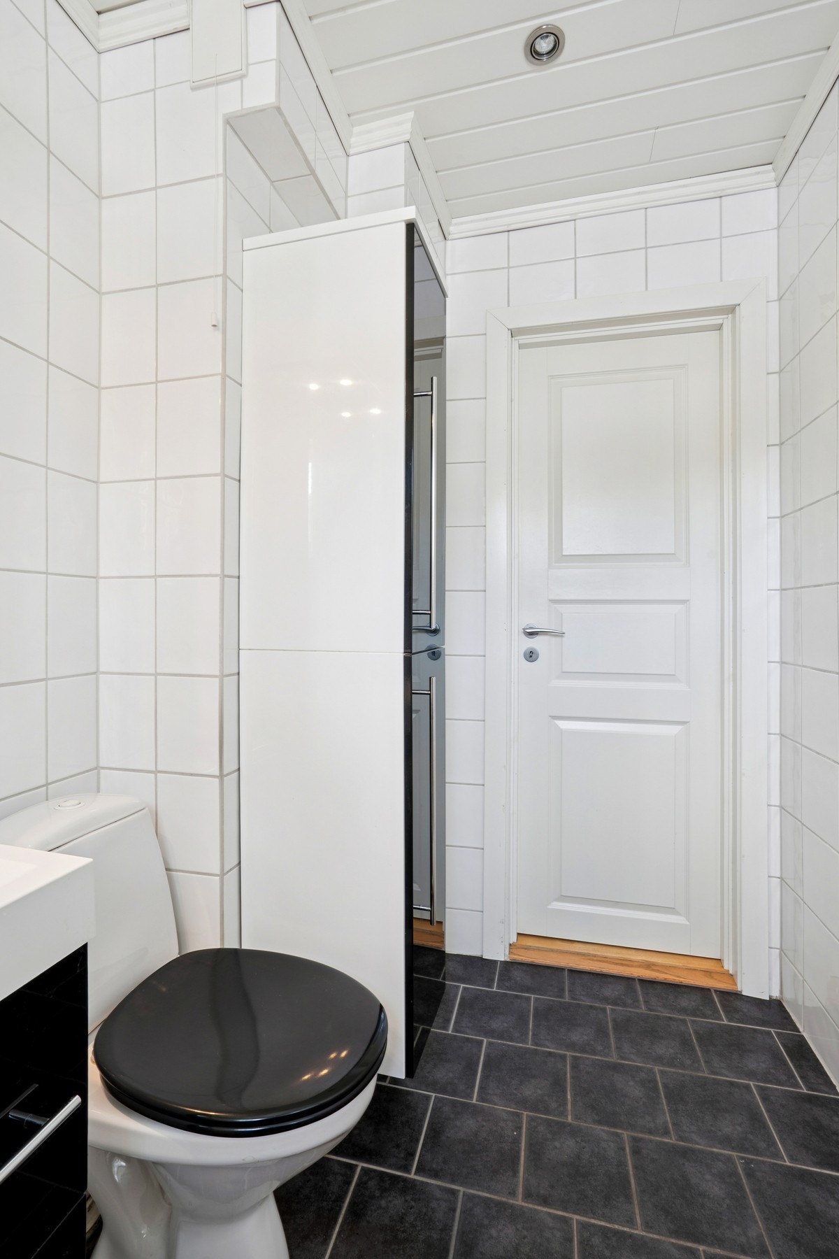 Flislagte vegger gjør renholdet enkelt, og et høyskap gir ekstra oppbevaringsplass. Galleribilde