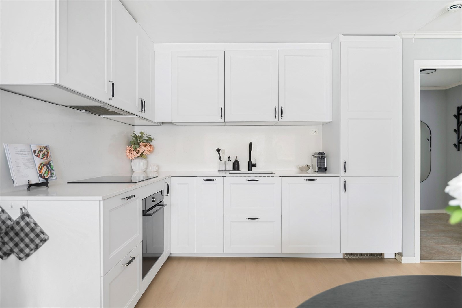 Lyst og gjennomført med profilerte skapfronter, samt benkeplate og bakplate i stein Galleribilde