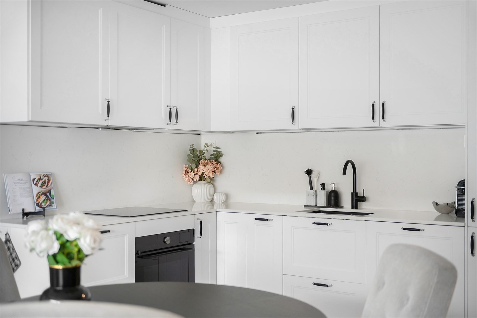 Delikat og tidløst kjøkken fra 2024 med integrerte hvitevarer og plass for spisebord Galleribilde