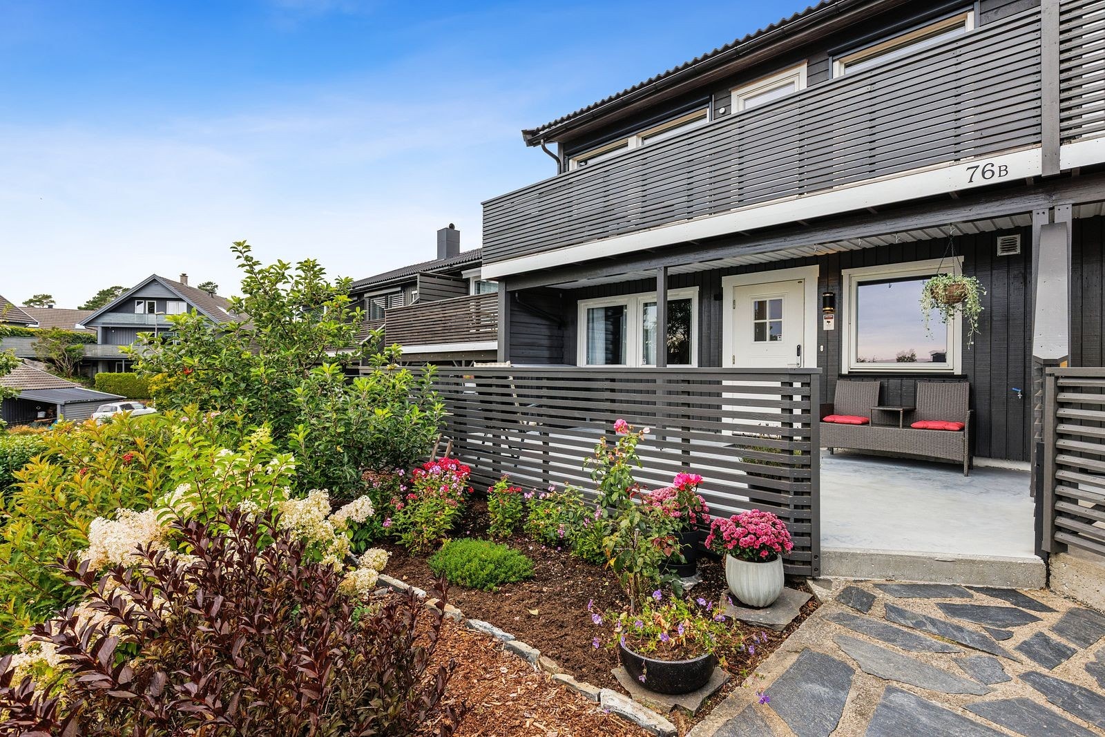 Hyggelig platting og bed med beplantning foran huset Galleribilde