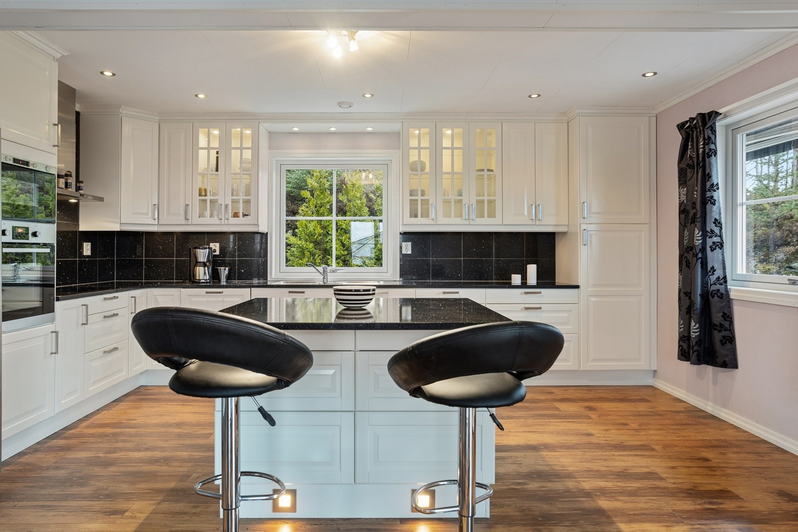 Kjøkkenet er utstyrt med en stilren kjøkkenøy som gir ekstra arbeidsplass. Galleribilde