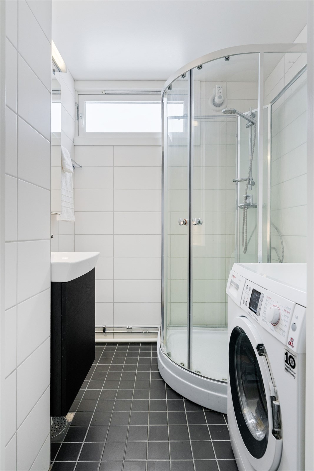 Flislagt bad med praktisk innredning. Opplegg for vaskemaskin. Galleribilde