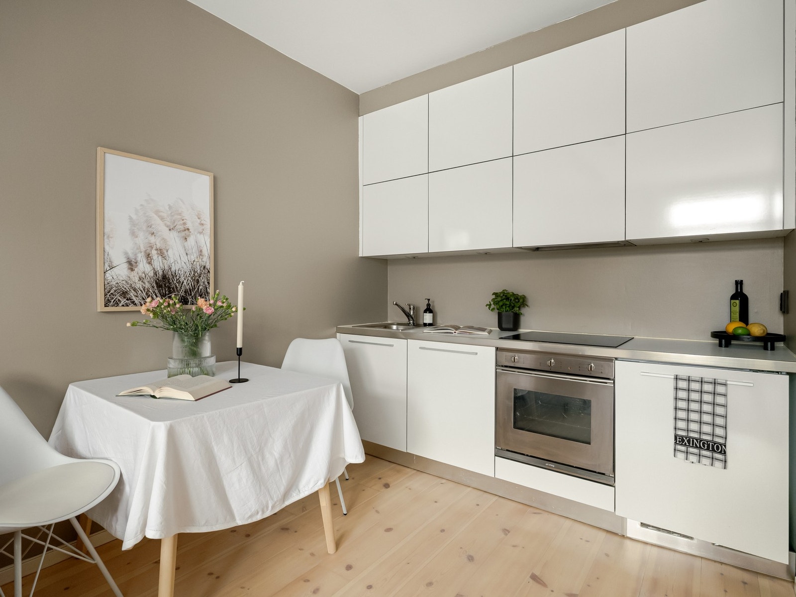 Det er integrerte hvitevarer med oppvaskmaskin, stekeovn, koketopp og kjøleskap under benkeplate. Galleribilde