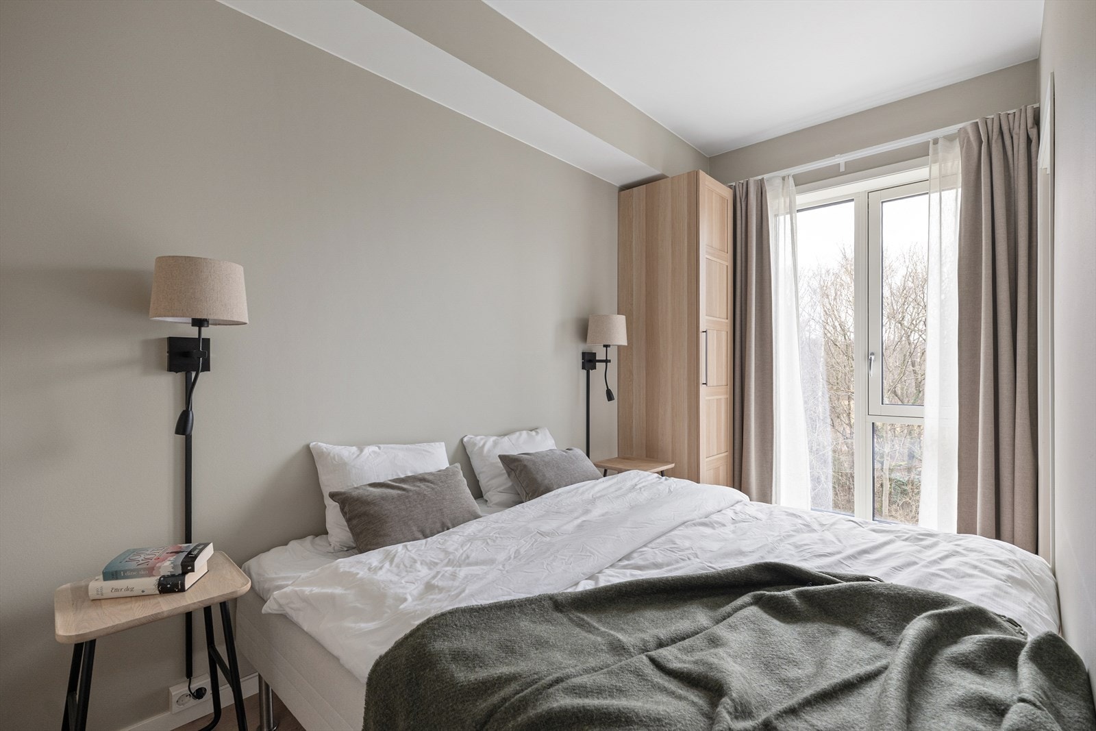 Lyst og harmonisk soverom med plass til dobbeltseng og garderobeløsning. Galleribilde