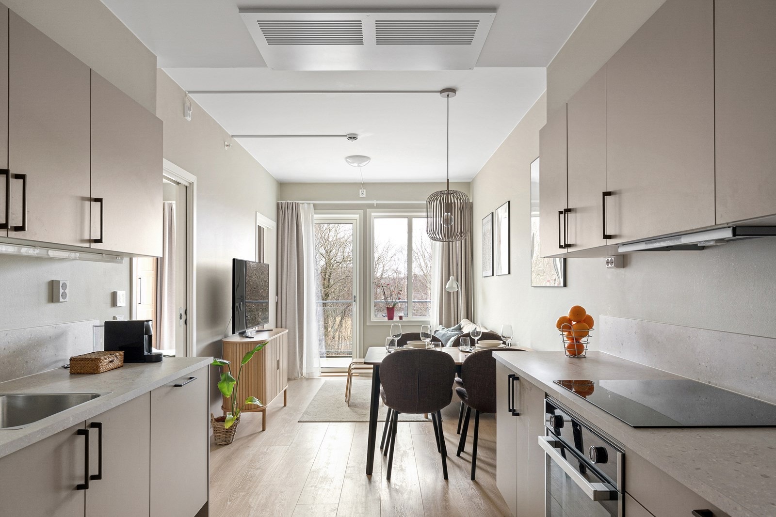 Lys stue med åpen løsning mot kjøkken og spiseplass. En effektiv planløsning som gir en sosial og funksjonell romfølelse. Galleribilde