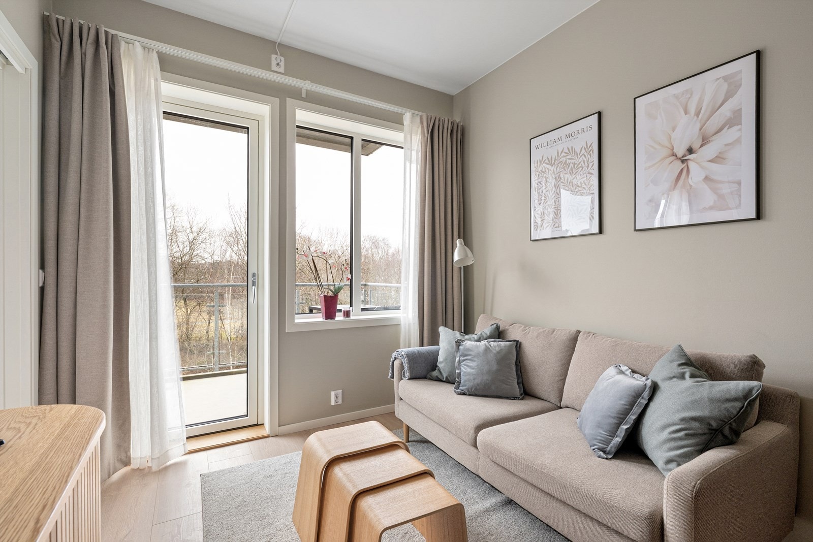 Innbydende stue med store vindusflater og utgang til balkong. Galleribilde